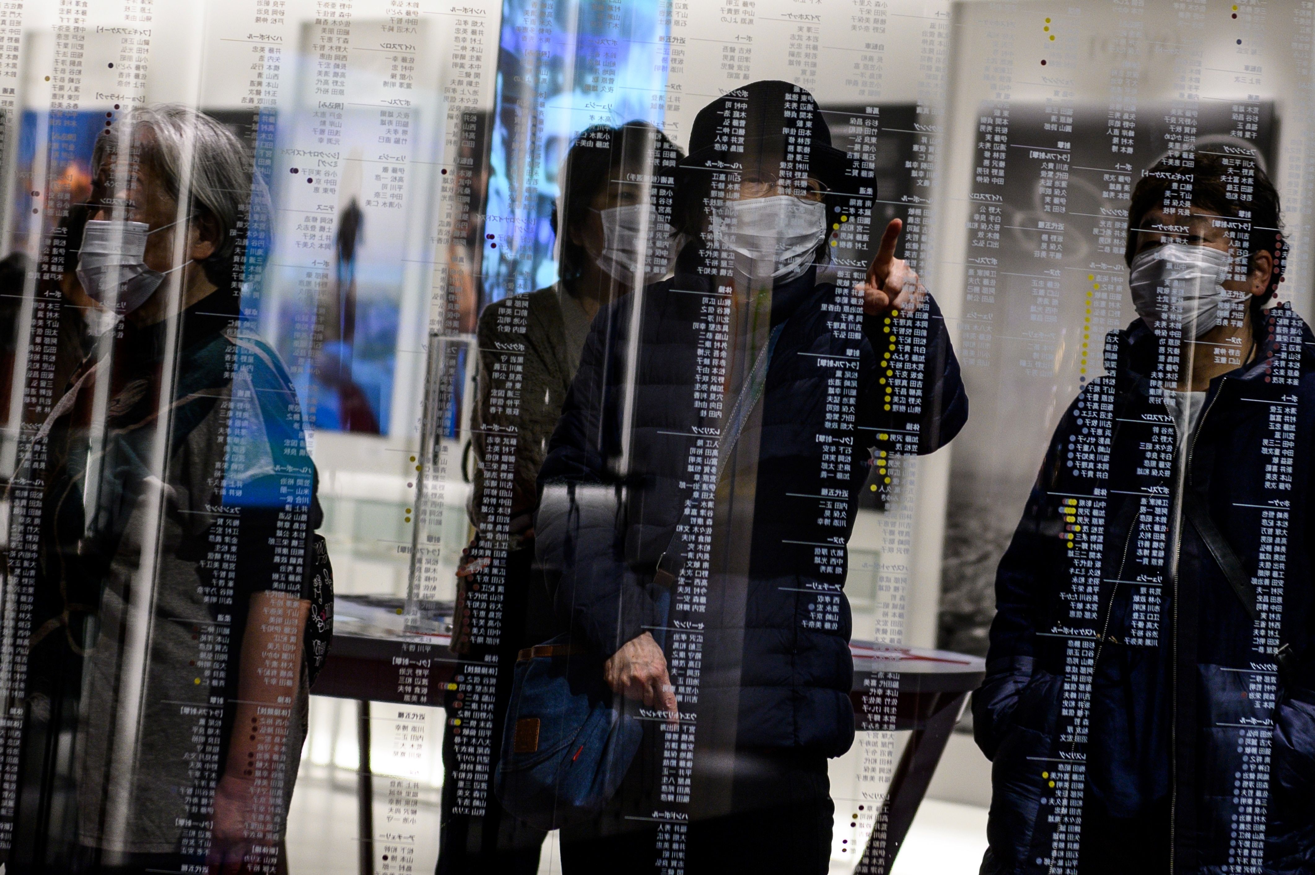 Pengunjung Japan Olympic Museum di Tokyo memakai masker agar tidak tertular COVID-19