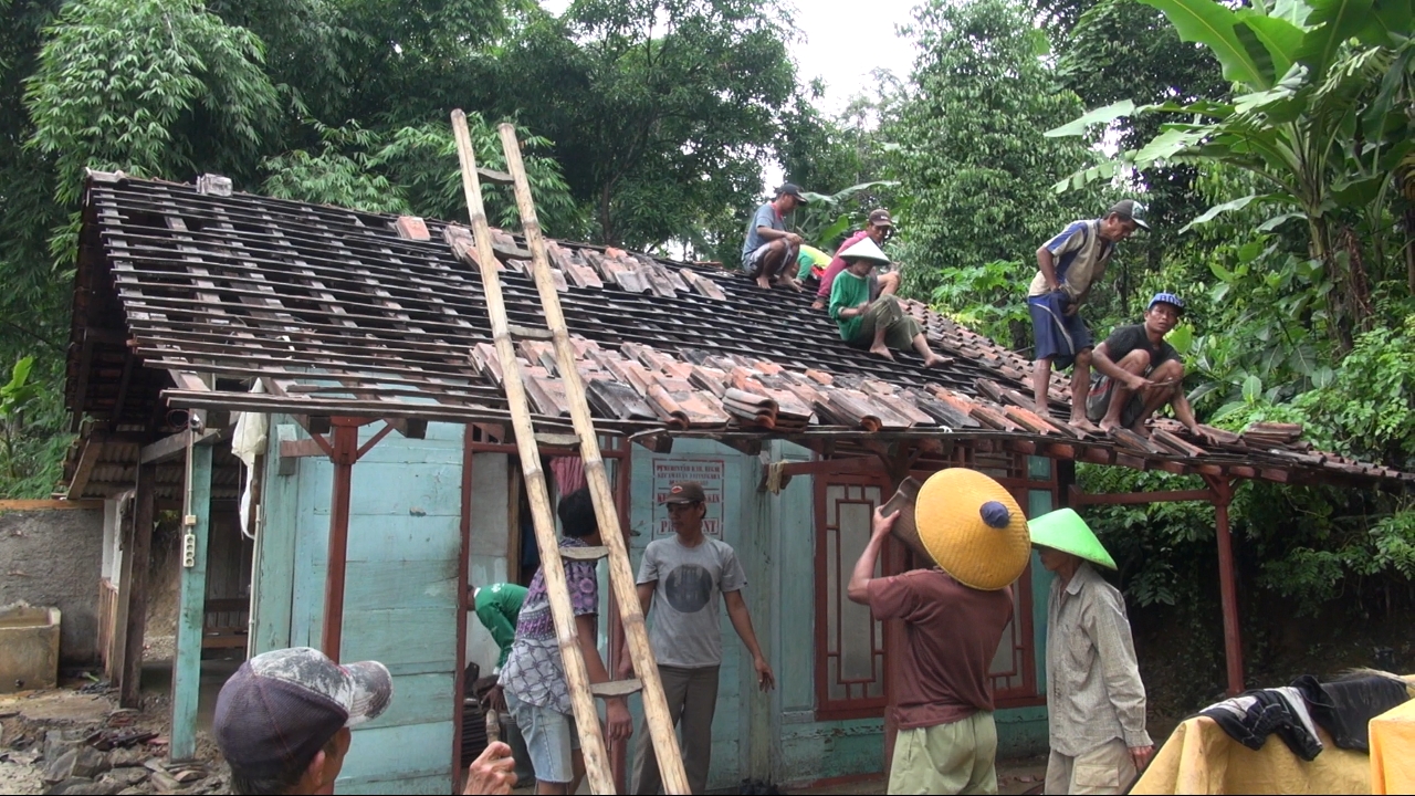 Warga sedang memperbaiki rumahnya yang rusal
