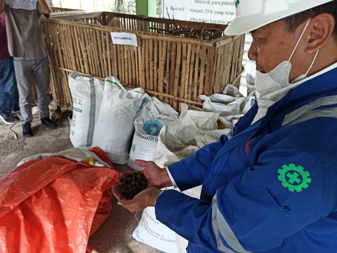 Petugas memperlihatkan pelet yang menjadi campuran bahan bakar guna menghasilkan listrik di PLTU Jeranjang.