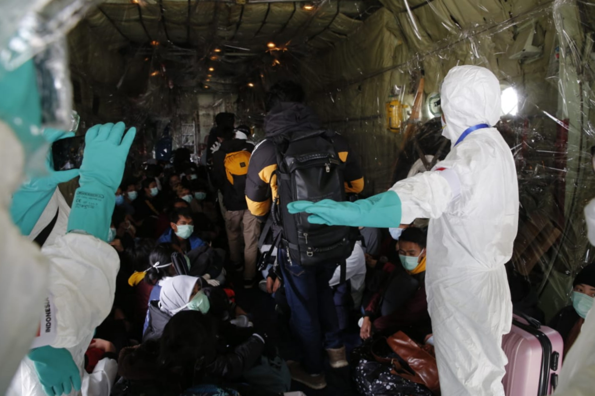 Petugas medis memeriksa kesehatan Warga Negara Indonesia (WNI) dari Wuhan, China setibanya di Pangkalan Udara Raden Sajad, Pulau Natuna.