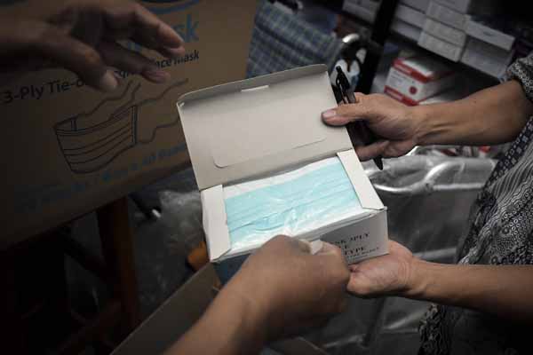 Pedagang melayani calon pembeli masker di Pasar Pramuka, Jakarta, Selasa (4/2).