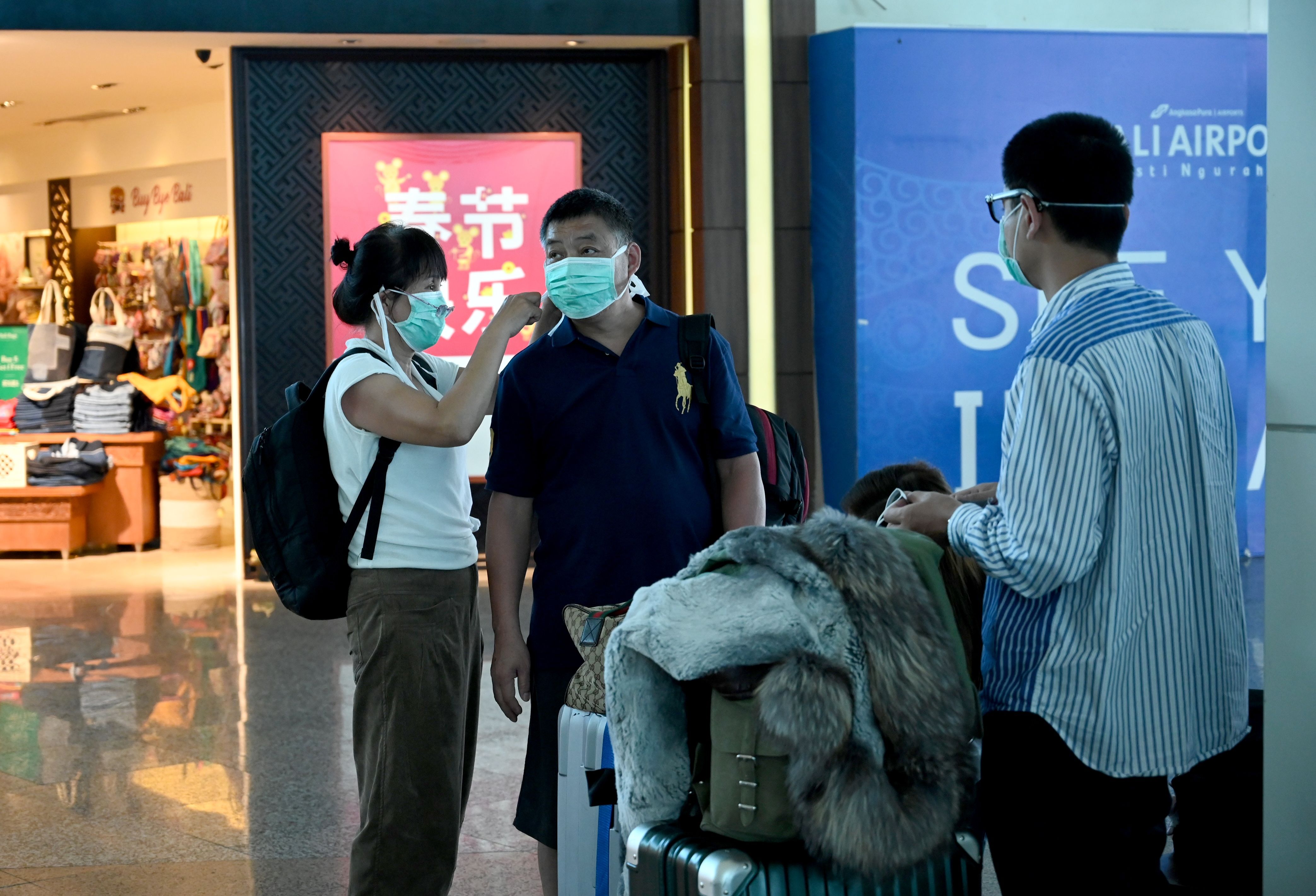 Turis asal Tiongkok mengenakan masker saat tiba di Bandara I Gusti Ngurah Rai, Bali.