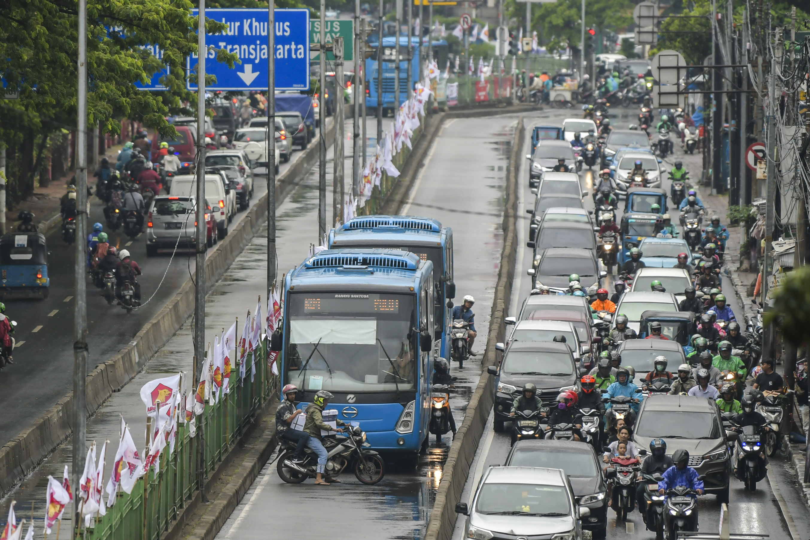 Pengendara motor berusaha keluar dari jalur bus Transjakarta untuk menghindari razia polisi di Jalan Sultan Agung, Jakarta.