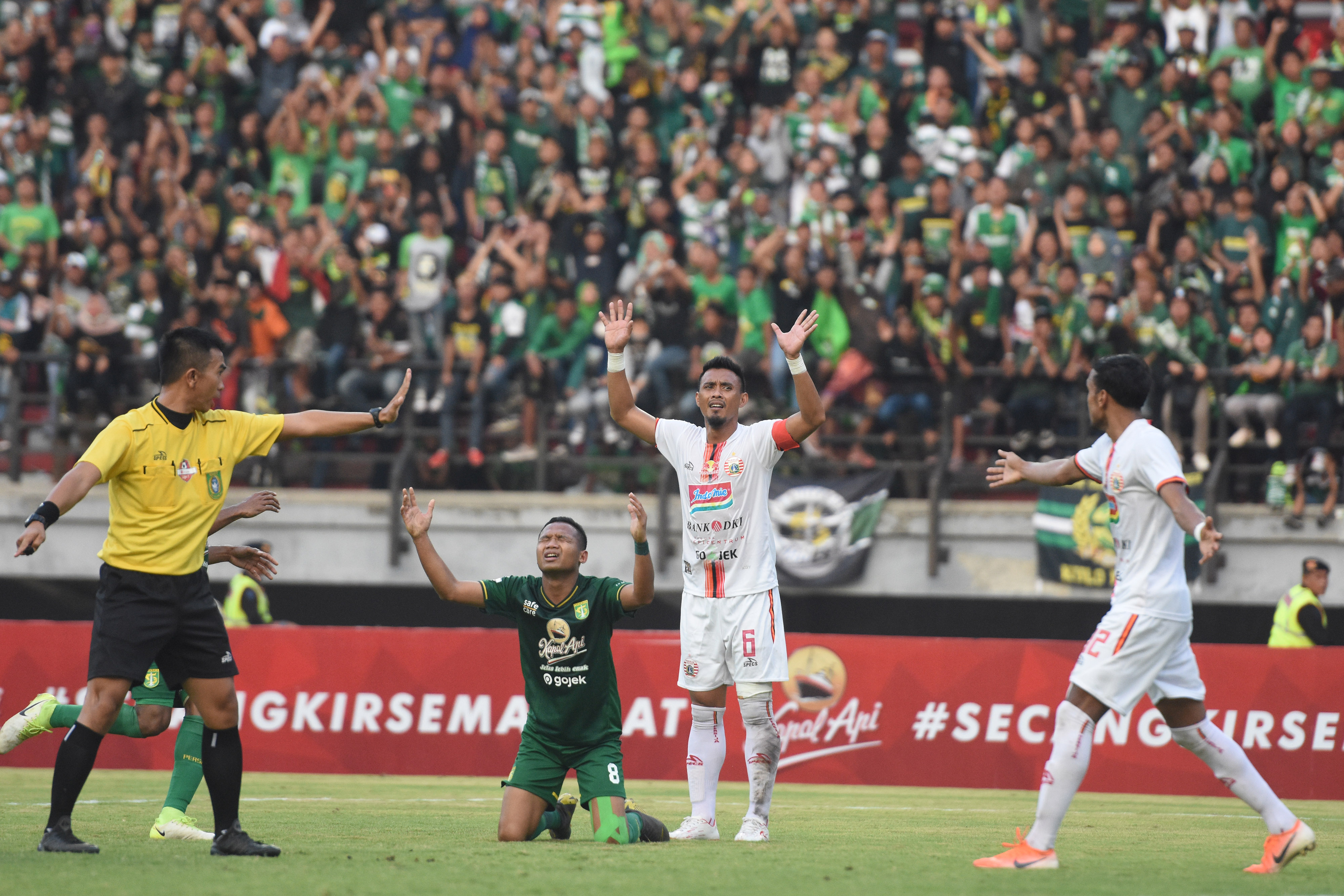 Wasit Aprisman Aranda (kiri) memimpin laga antara Persija dan Persebaya.