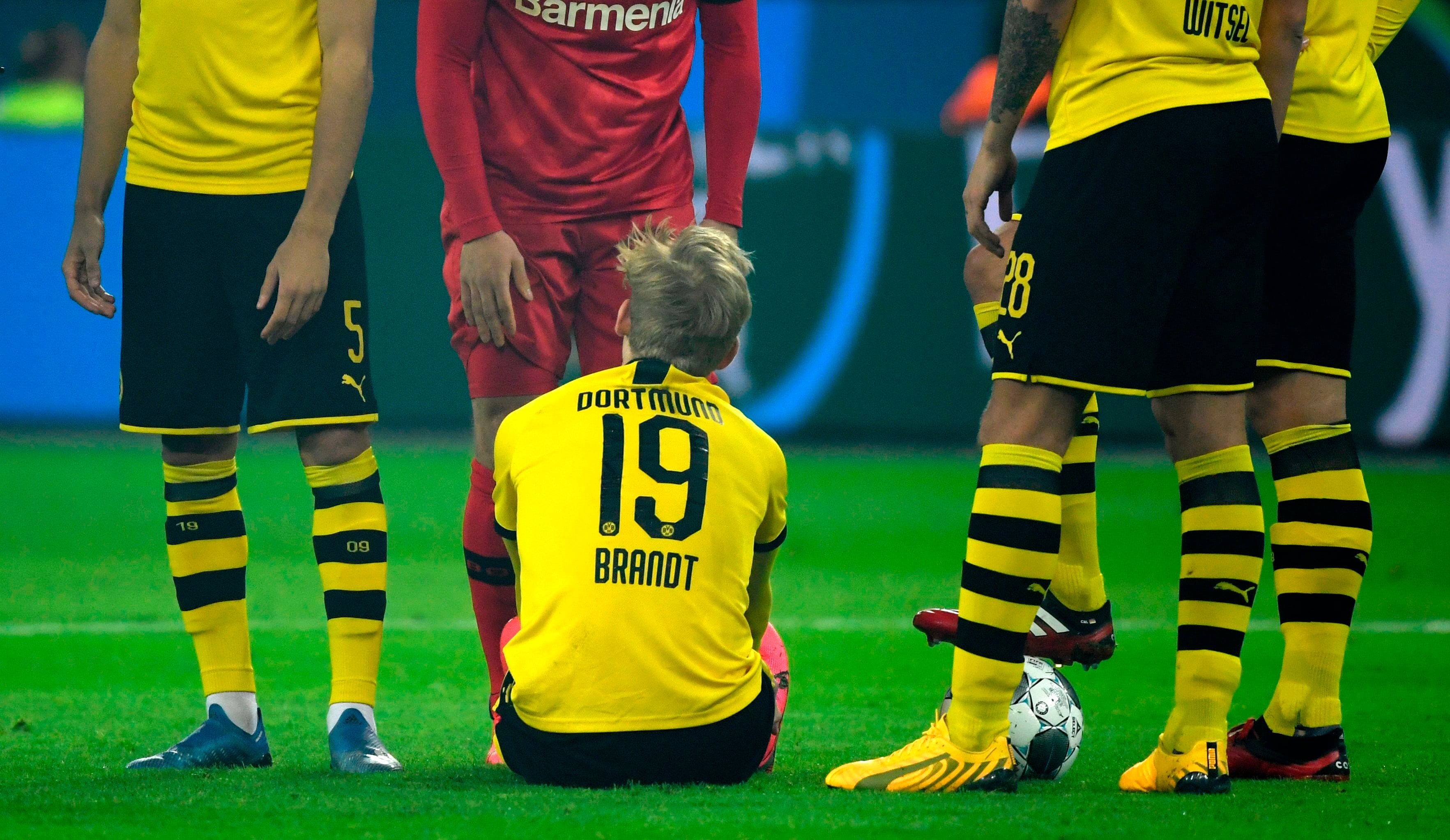 Julian Brandt (duduk) mengalami cedera dalam laga antara Borussia Dortmund dan Bayer Leverkusen.