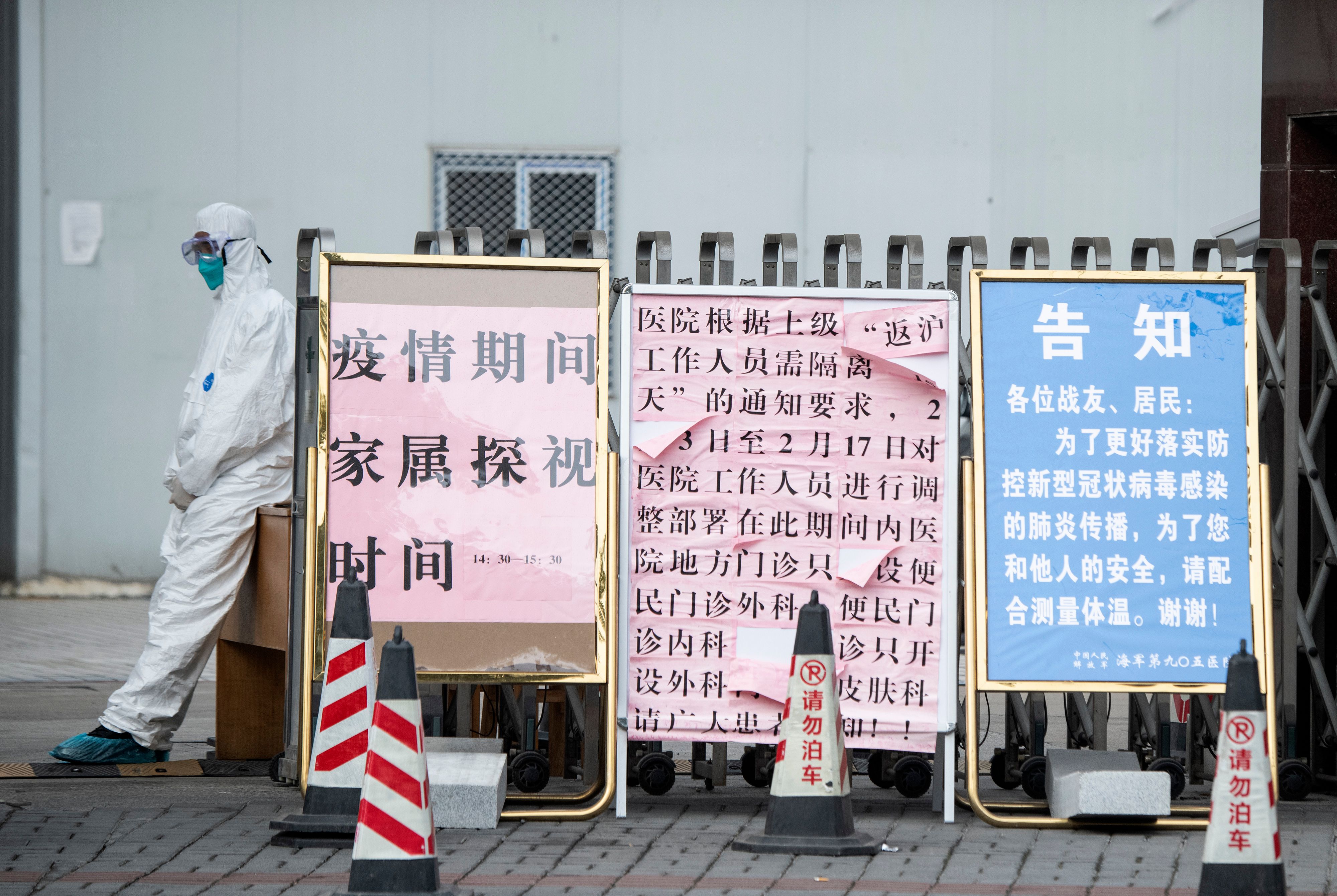Seorang penjaga keamanan mengenakan masker pelindung saat berdiri di pintu masuk rumah sakit di Shanghai, Tiongkok.