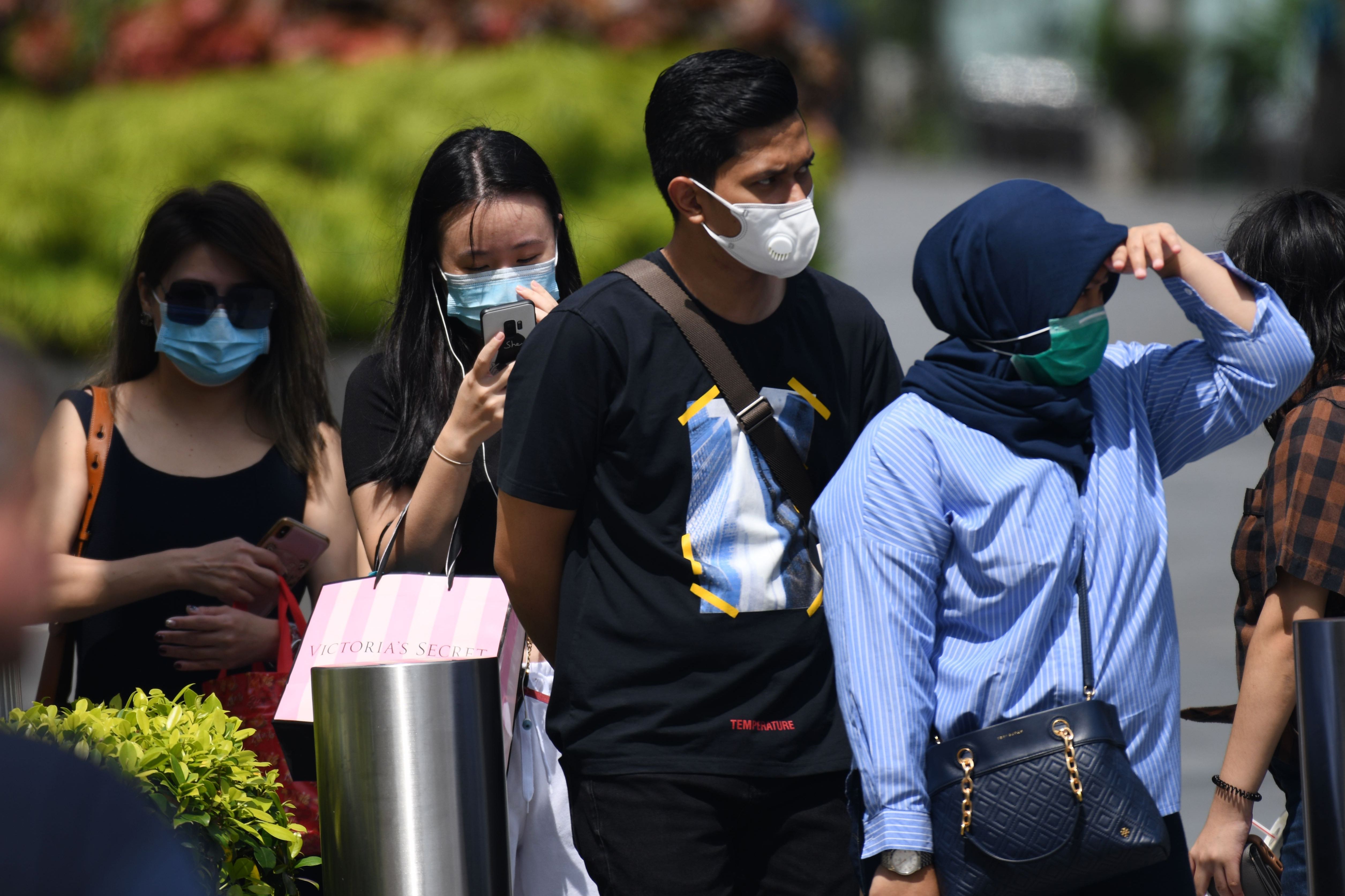 Warga Singapura memakai masker saat bekegiatan di luar rumah