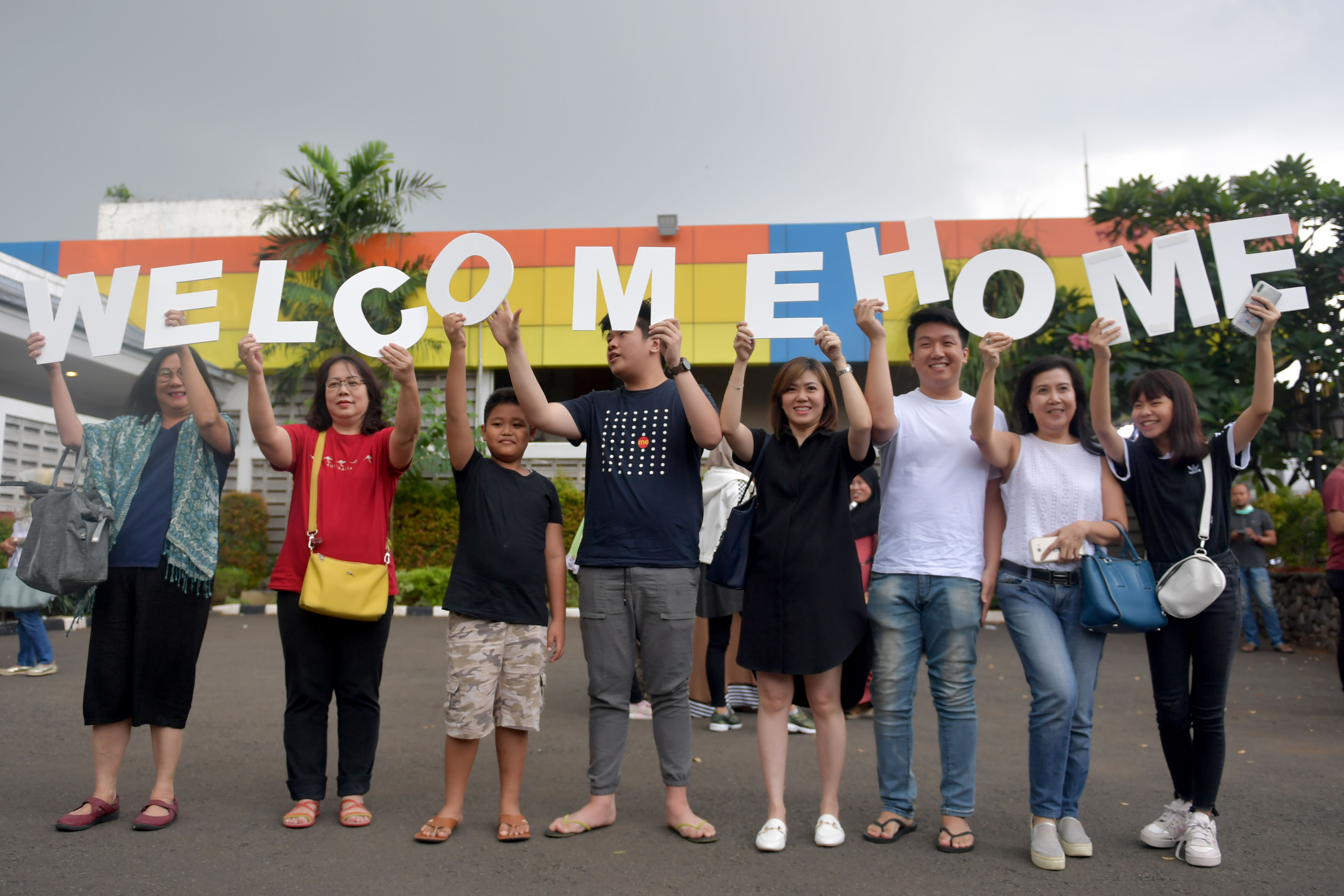 Keluarga Warga Negara Indonesia (WNI) yang dievakuasi dari Wuhan,Hubei, Tiongkok mengangkat tulisan 'Welcome Home'.