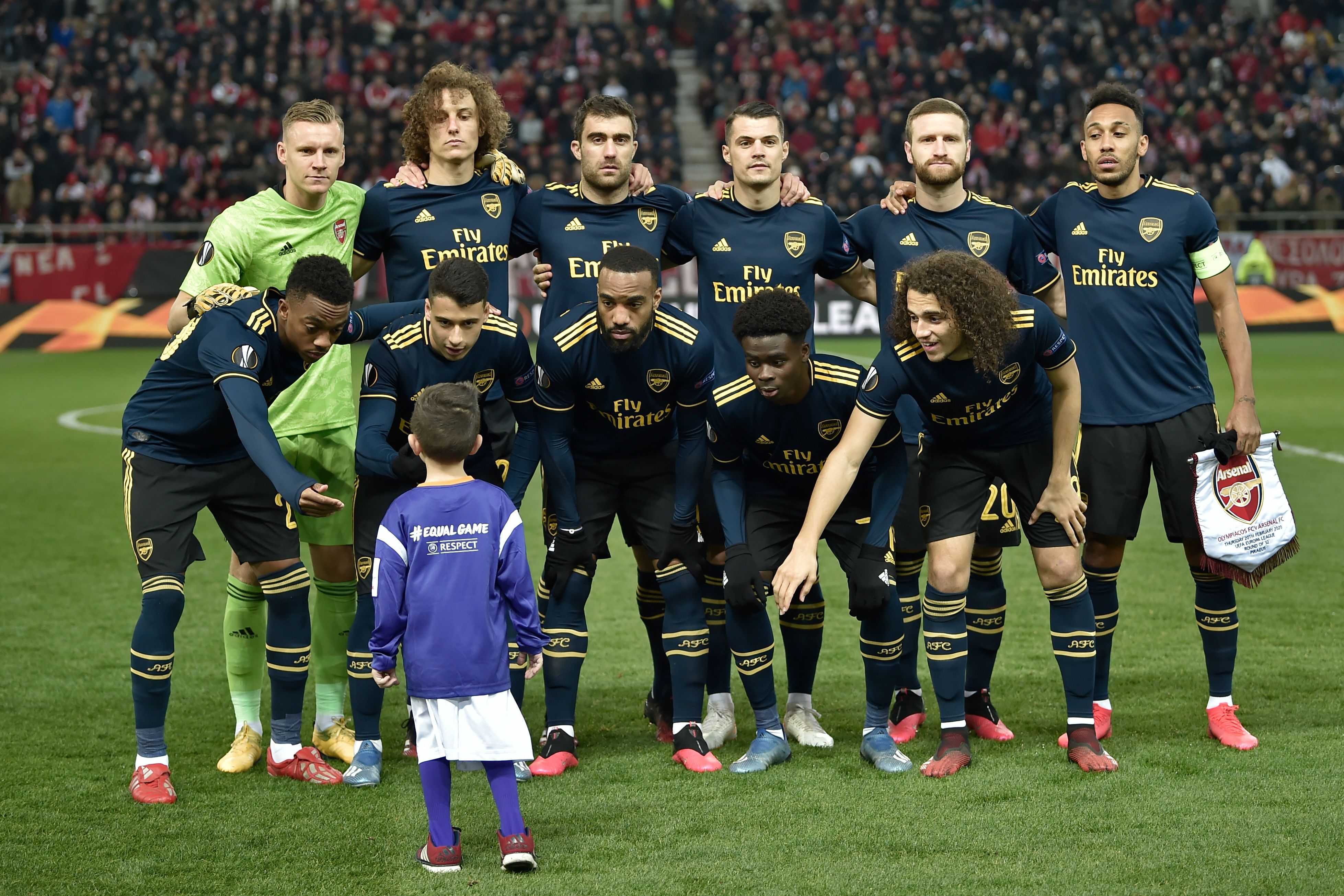 Pemain Arsenal membujuk anak yang menjadi pendamping pemain (player escort) untuk berfoto bersama dengan tim, kemarin.