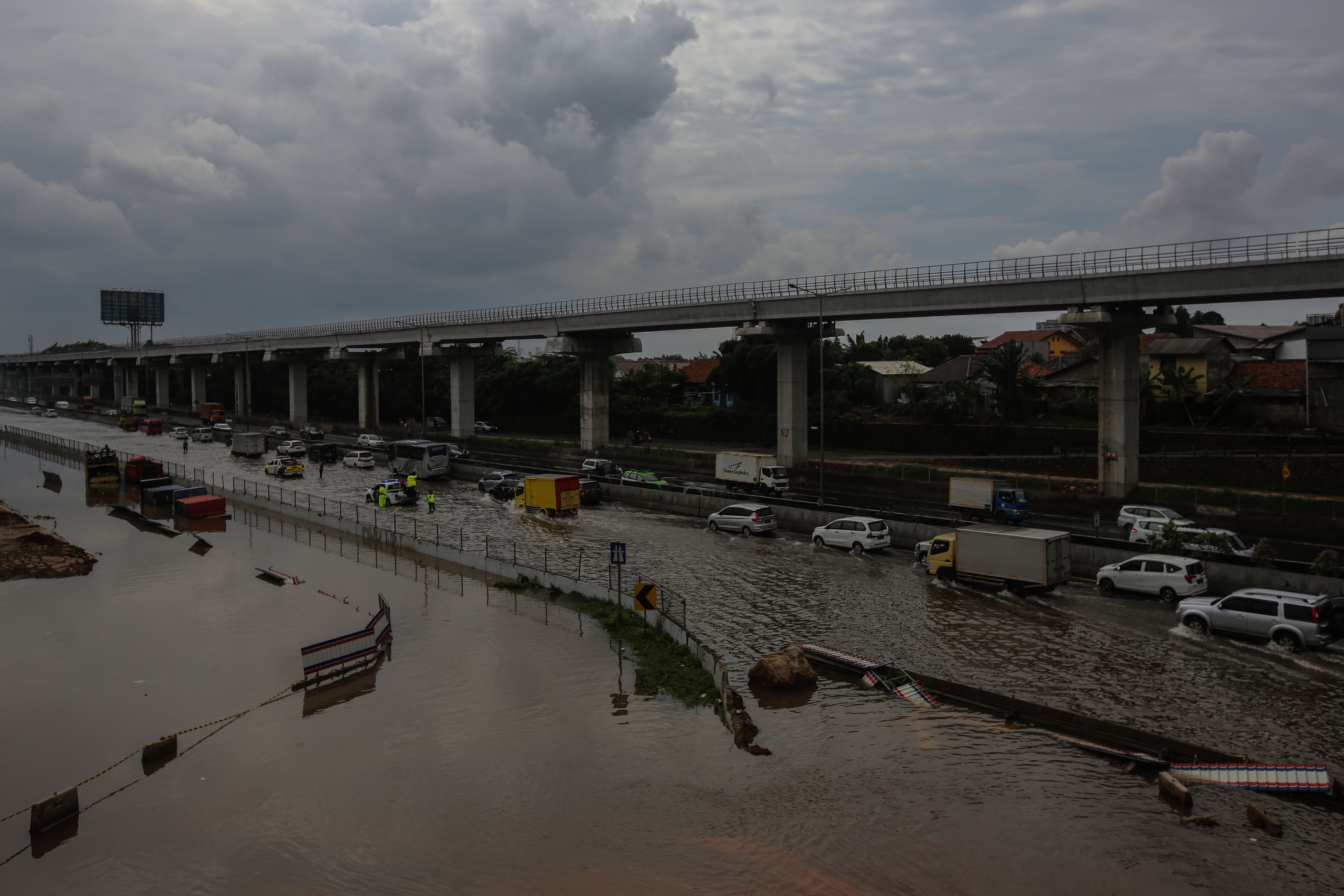 Pengendara memperlambat laju kendaraan saat melewati banjir ruas tol Jakarta-Cikampek kawasan Jatibening, Bekasi, Selasa (25/2/2020)