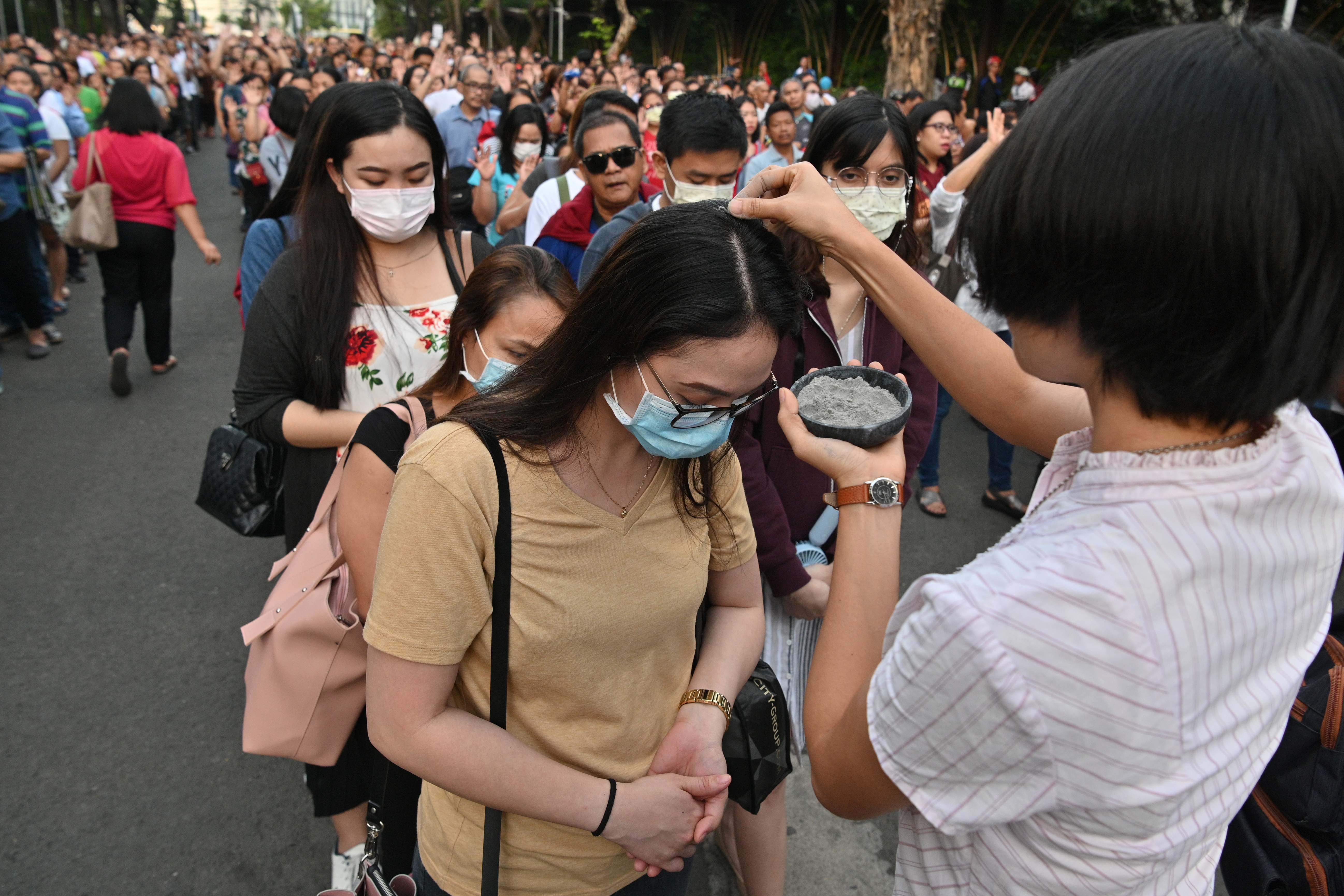 Seorang suster menaburi abu ke kepala umat saat perayaan Rabu Abu di Manila, Filipina.