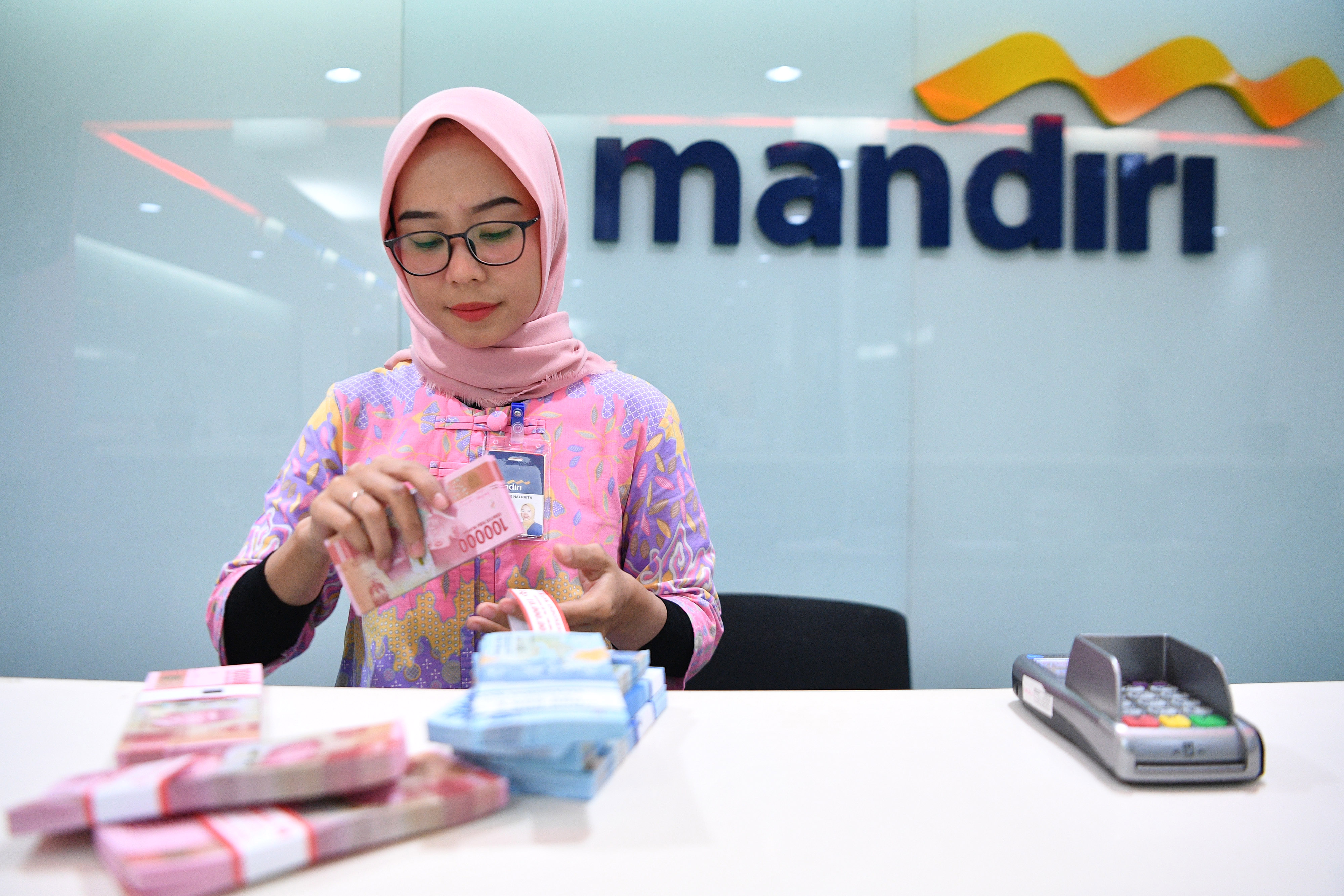  Karyawan mengenakan baju batik saat beraktivitas di Bank Mandiri Cabang Plaza Mandiri, Jakarta, Rabu (2/10/2019).