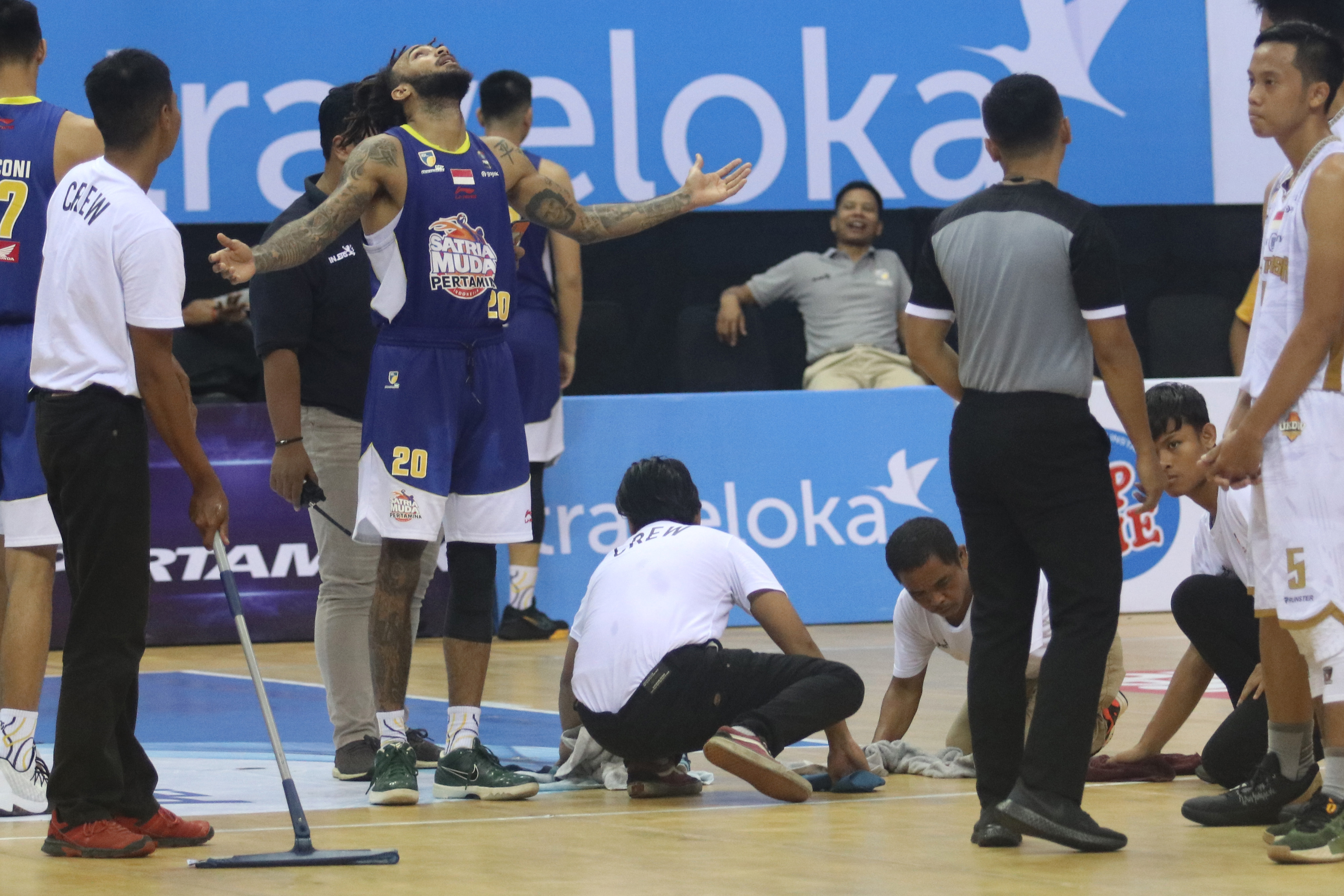Petugas membersihkan lapangan dari air hujan di GOR Jayabaya, Kediri, Jawa Timur, hari ini.