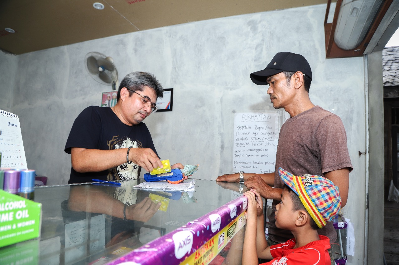 Agen BRILink sedang melayani transaksi pelanggan. 