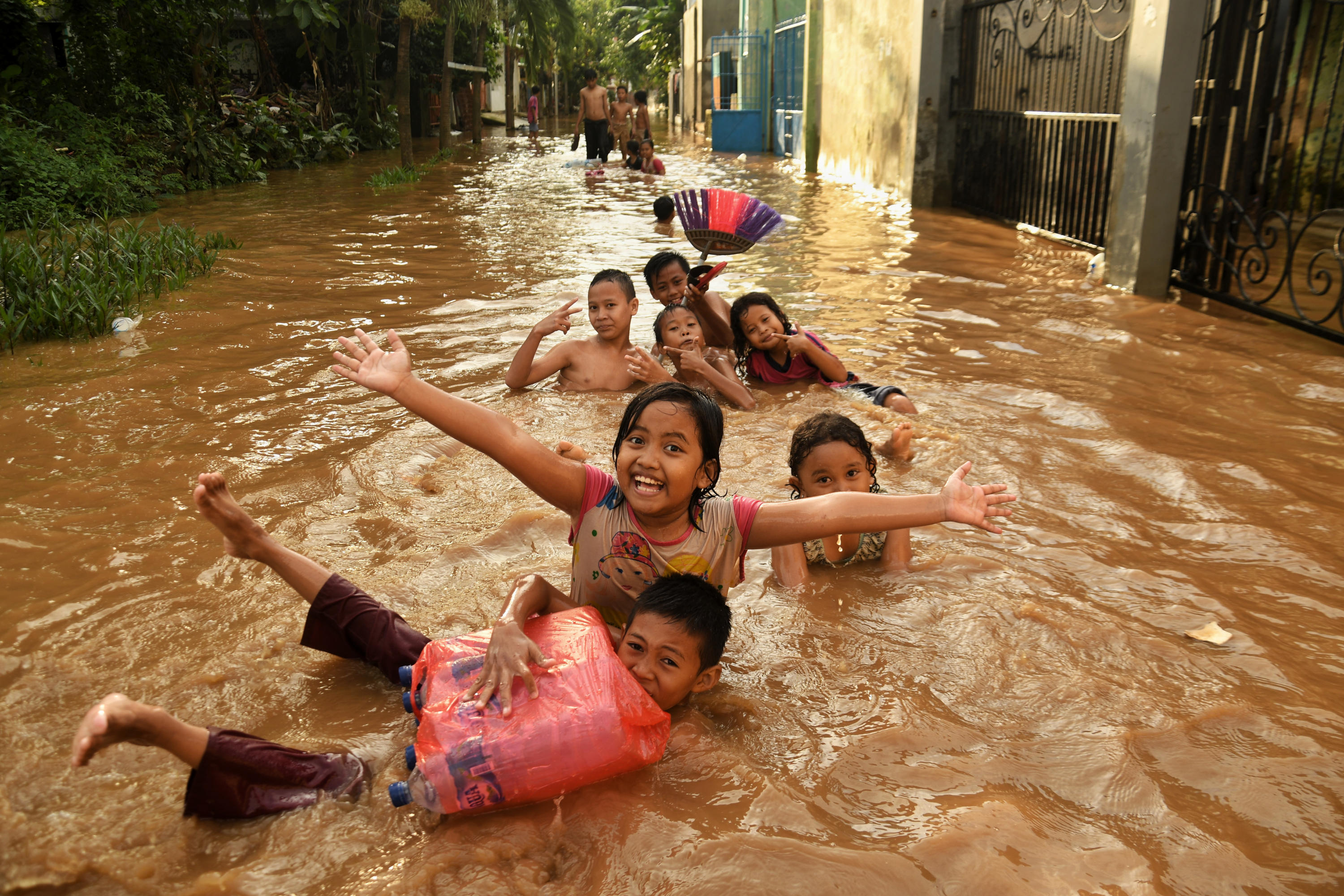 Sejumlah anak bermain air banjir yang melanda kawasan rw.08 Kelurahan Cawang, Jakarta Timur.