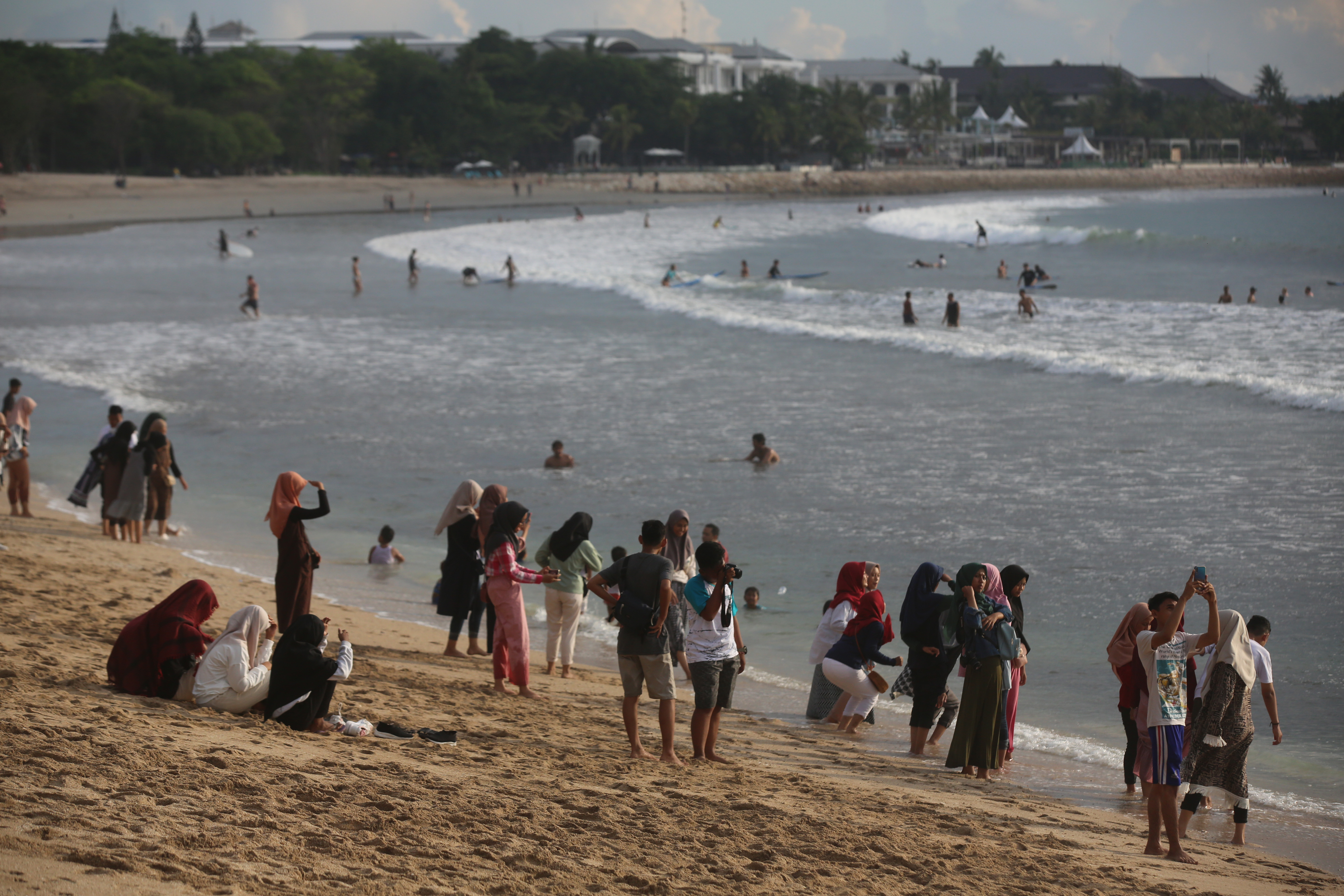 Wisatawan menikmati keindahan pantai di kawasan Kuta, Bali. Namun, wabah virus korona memengaruhi sektor pariwisata.