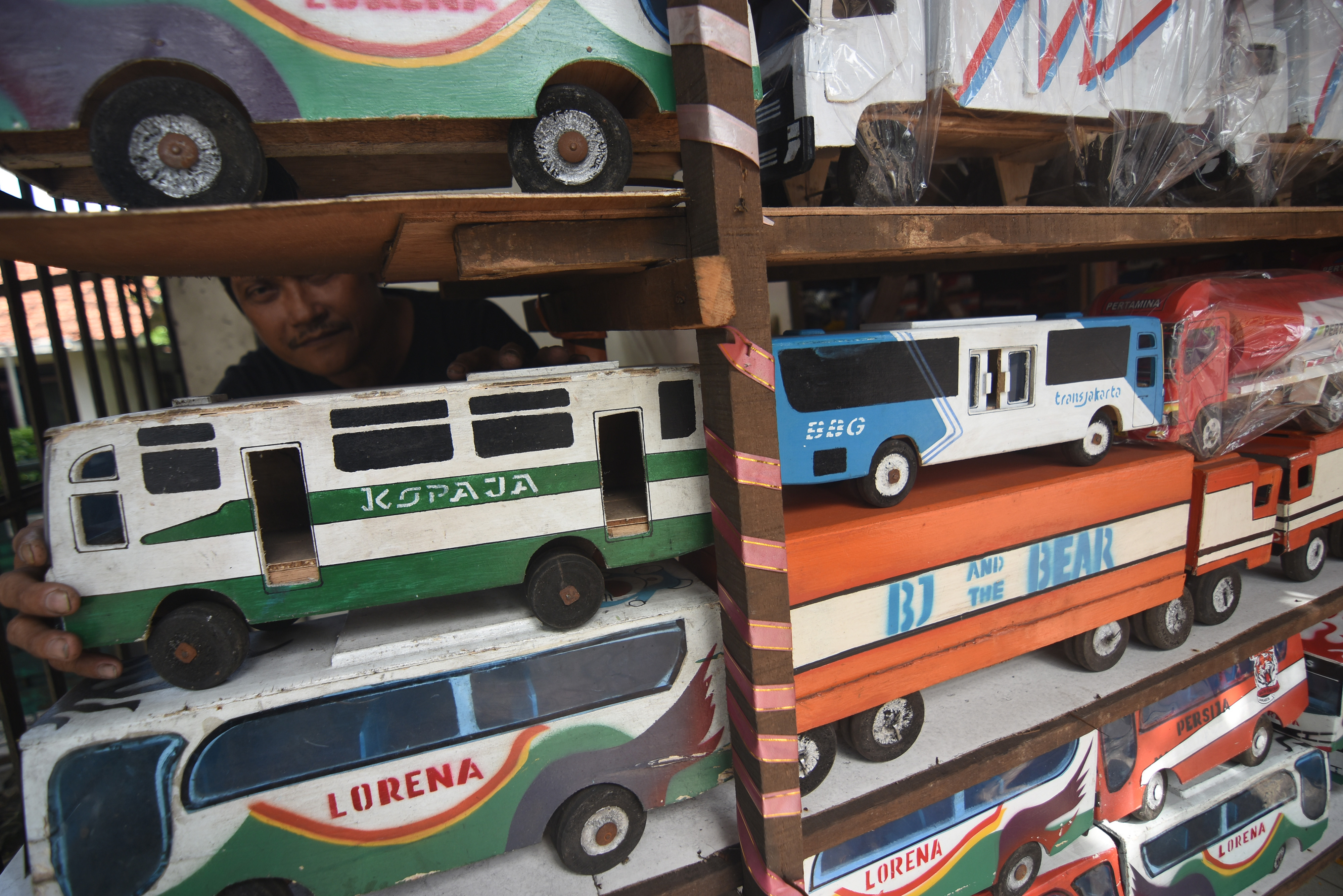  Pedagang menata kerajinan mobil mainan berbahan kayu di kiosnya di kawasan Kalibata, Jakarta, Jumat (21/2/2020).