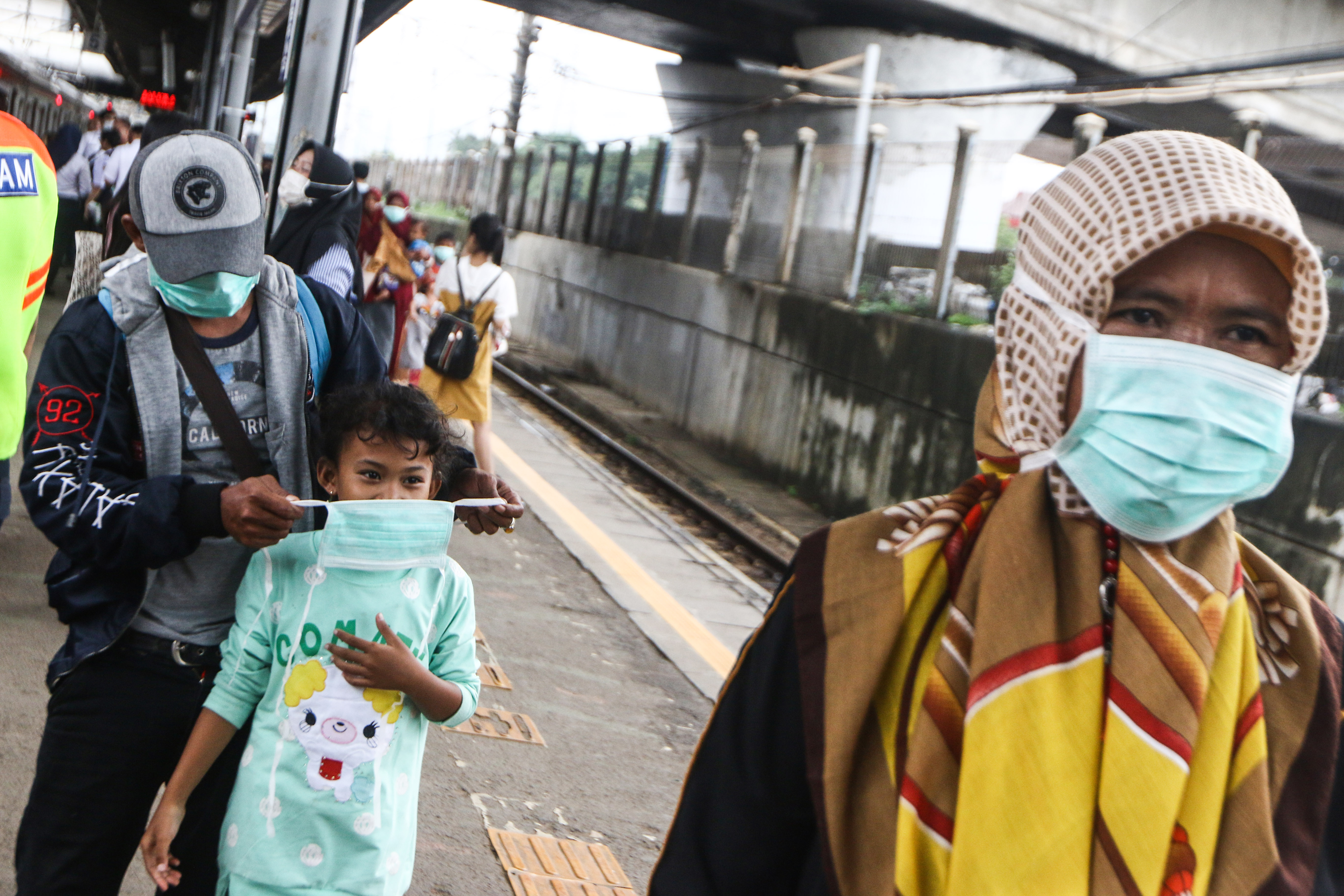 Penumpang menggunakan masker dari PT KCI secara gratis untuk mencegah virus korona di Stasiun Tanah Abang, Jakarta.  