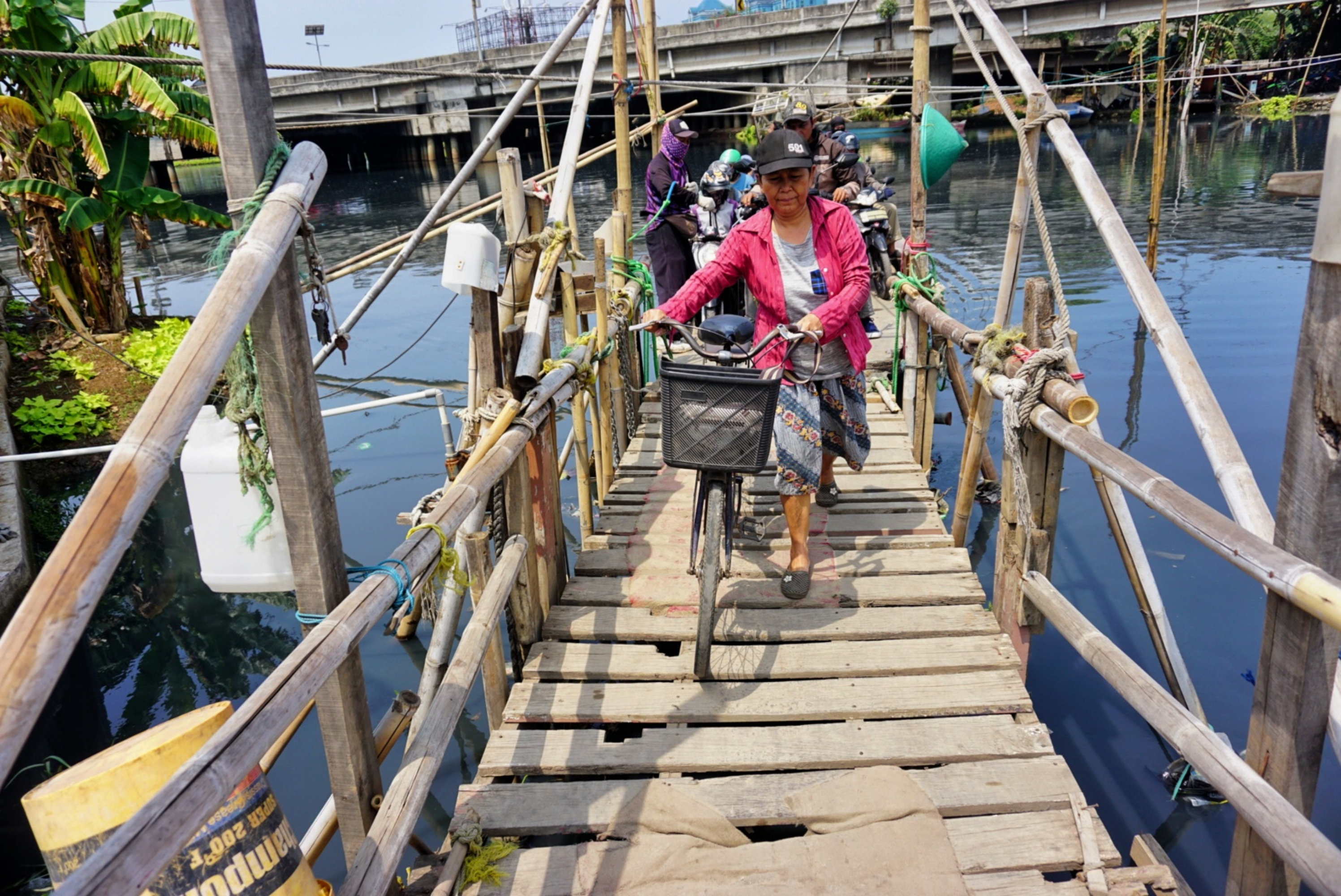Sejumlah kendaraan menggunakan perahu getek menyebrangi Kali Cagak, Muara Karang, Jakarta Utara.