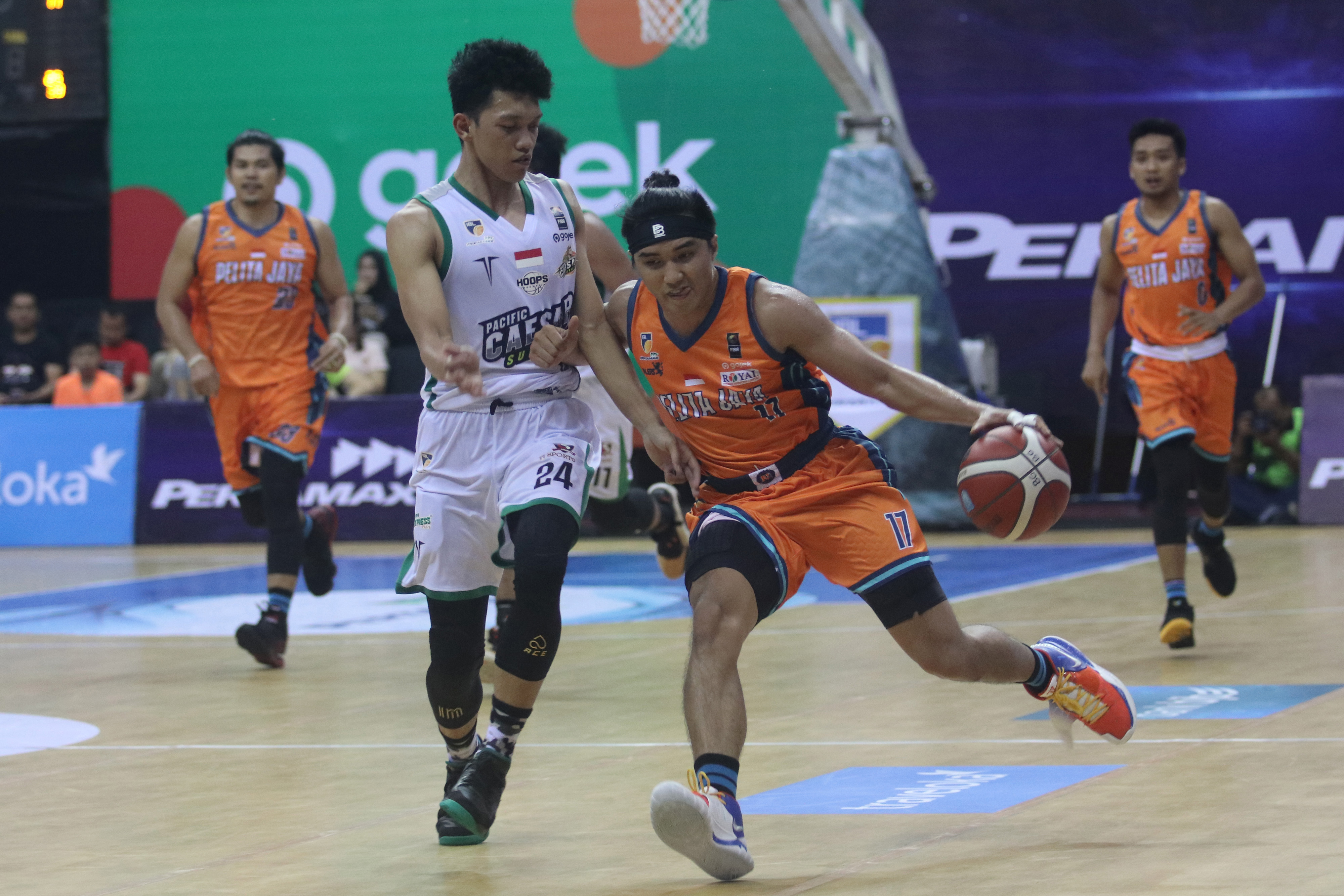 Pebasket Pelita Jaya yang menguasai bola dihalangi pebasket Pacific Caesar Surabaya saat pertandingan Indonesian Basketball League.