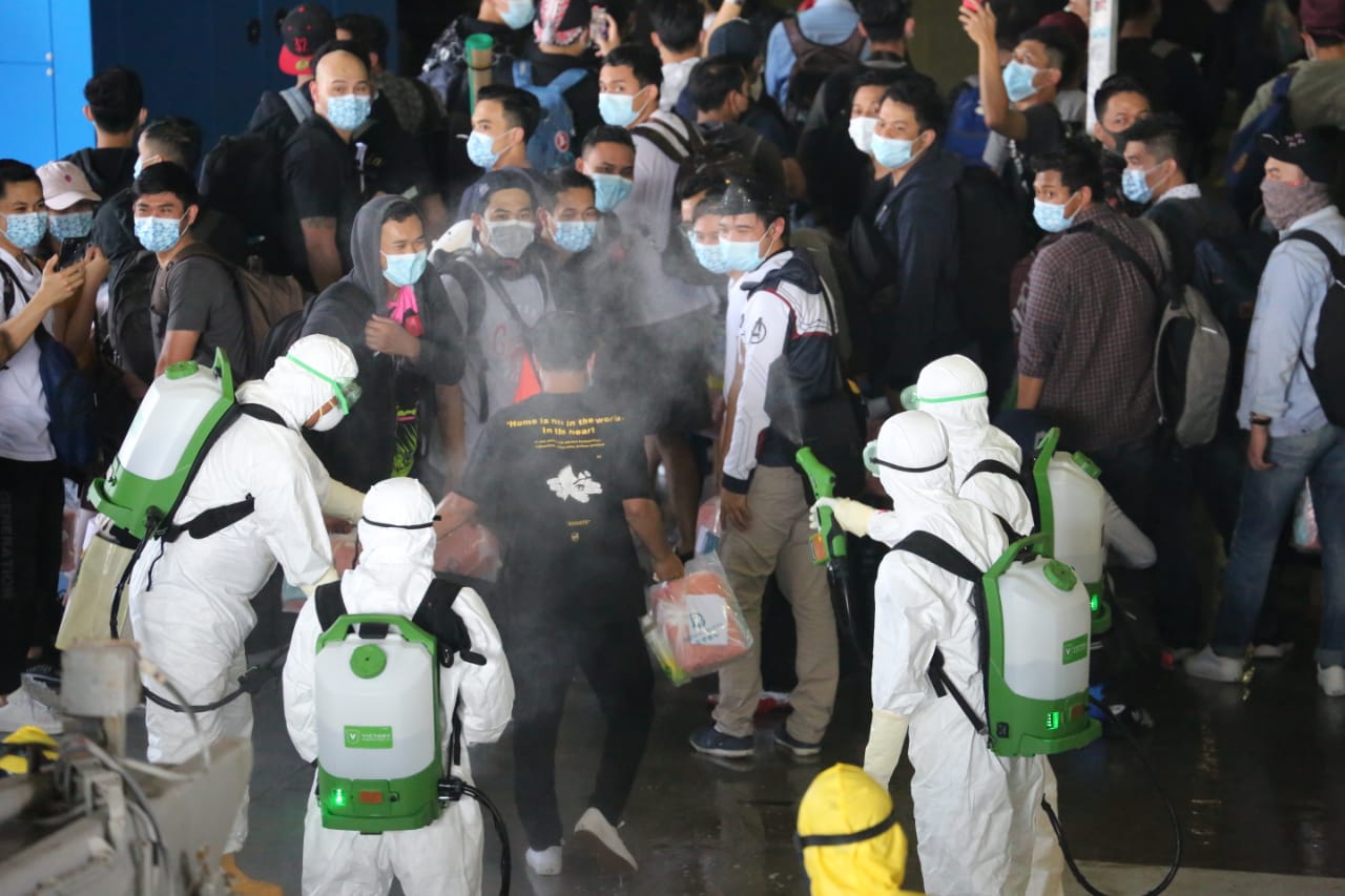 Petugas menyemprotkan cairan disinfektan kepada WNI kru kapal pesiar World Dream yang baru tiba di KRI dr. Soeharso.