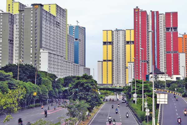 Pengendara melintas dengan latar belakang Wisma Atlet di Kemayoran, Jakarta, kemarin.