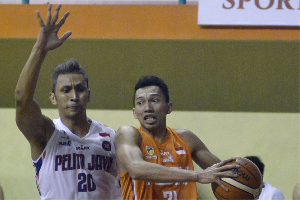 Pebola basket Pelita Jaya Basketball Govinda Julian Saputra (kiri) berebut bola dengan pebola basket NSH Jakarta Muhamad El Islamy.