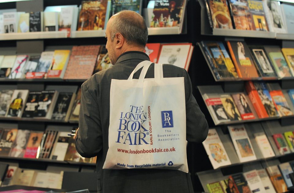 Seorang pria memegang totebag London Book Fair
