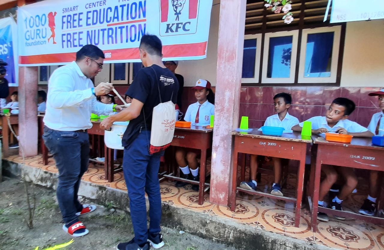 General Marketing PT. Fast Food Tbk., Hendra Yuniarto memberikan sarapan kepada siswa Siswa SD Inpres Bunaken, Manado, Minggu (8/3)