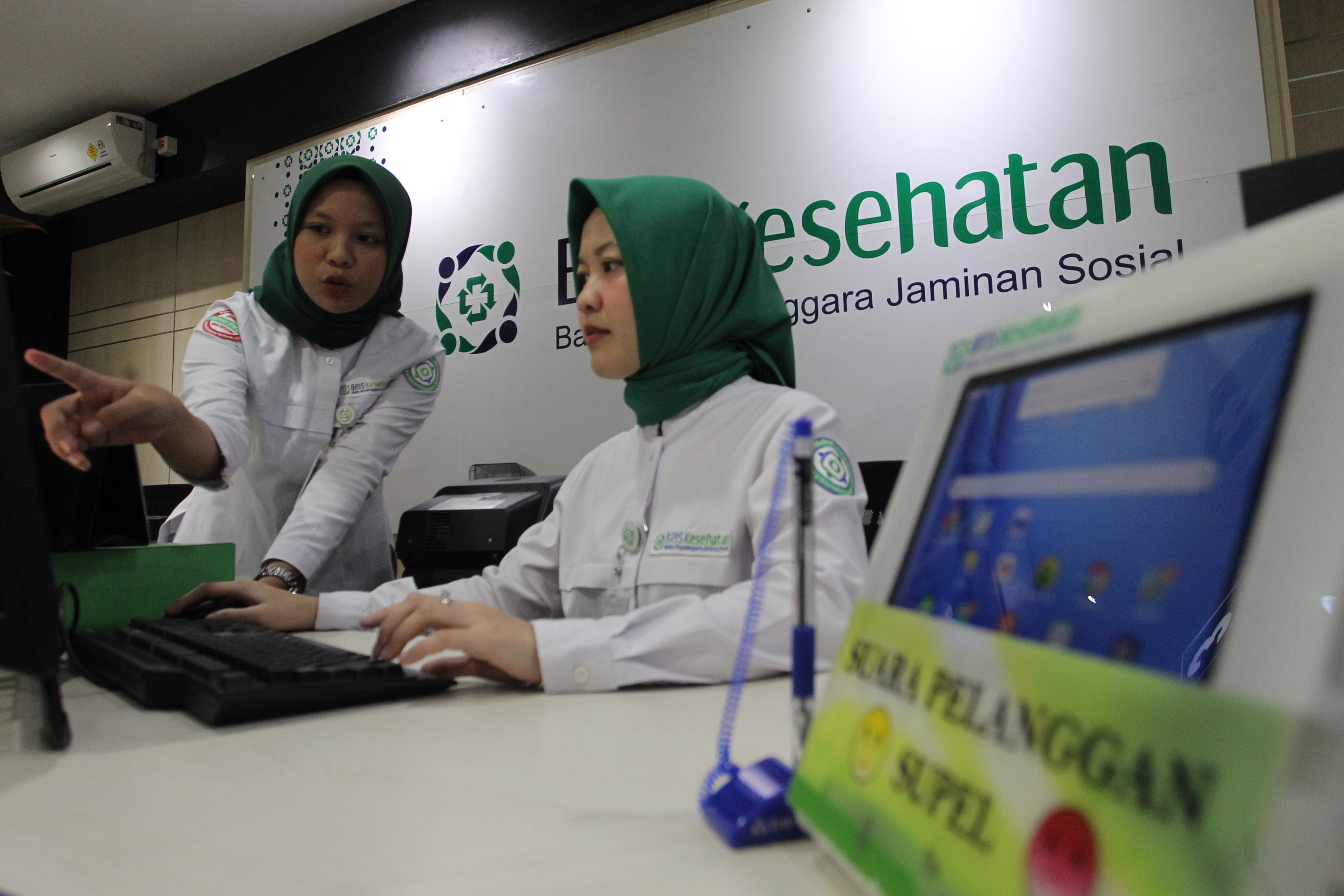 Pegawai BPJS Kesehatan memasukkan data nasabah, menyusul keputusan Mahkamah Agung yang membatalkan penaikan iuran.