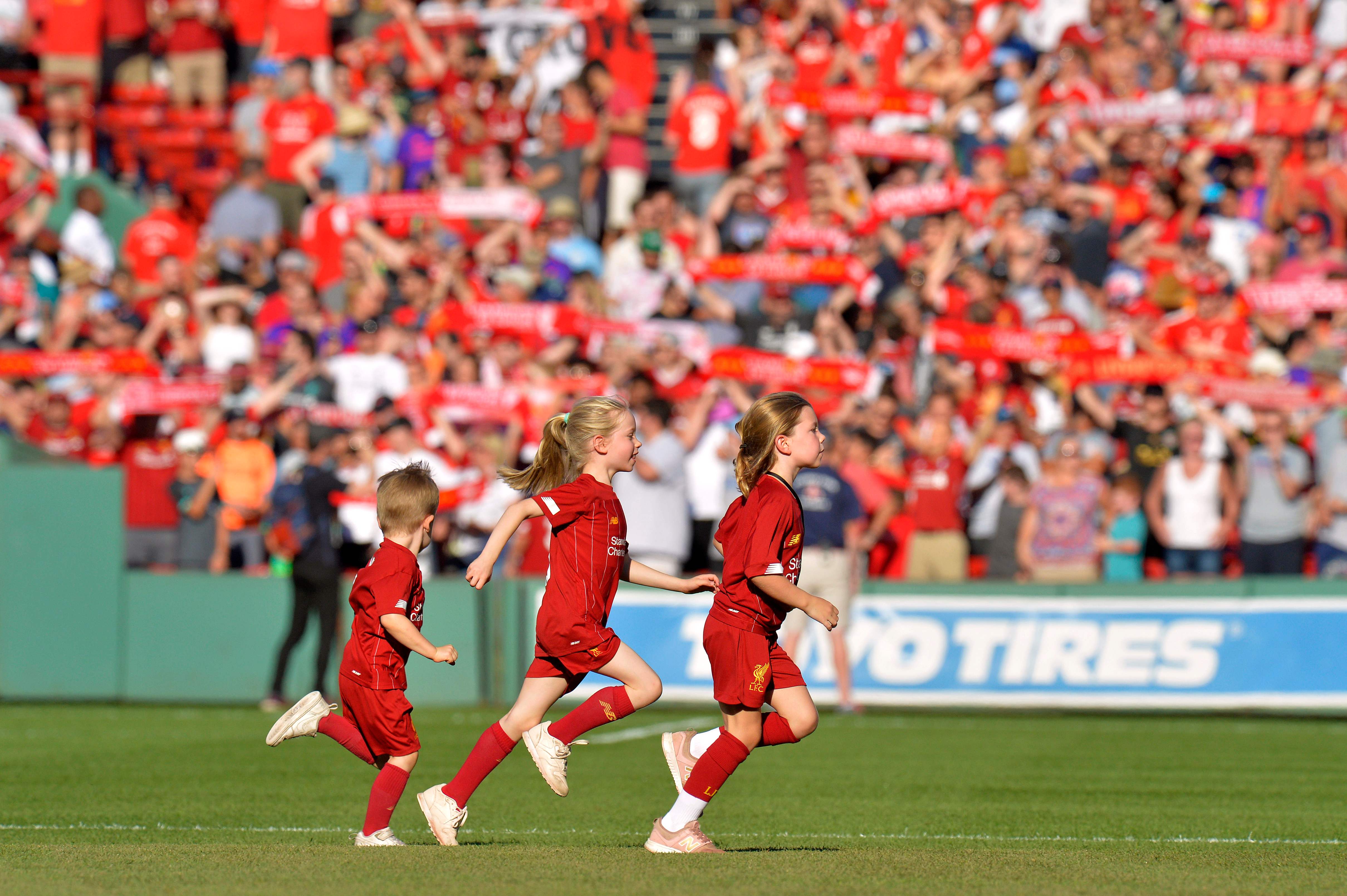 Sejumlah anak mengenakan jersey Liverpool masuk ke lapangan sebelum laga persahabatan antara the Reds dan Sevilla.