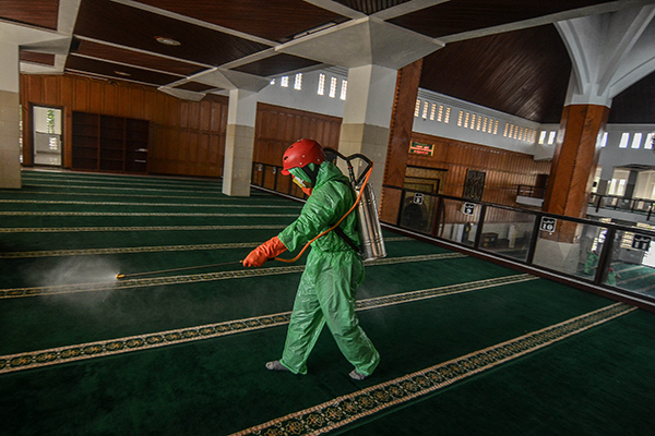 Petugas menyemprotkan cairan disinfektan di Masjid Agung Kota Tasikmalaya, Jabar, Rabu (18/3) sebagai upaya mencegah penyebaran virus korona