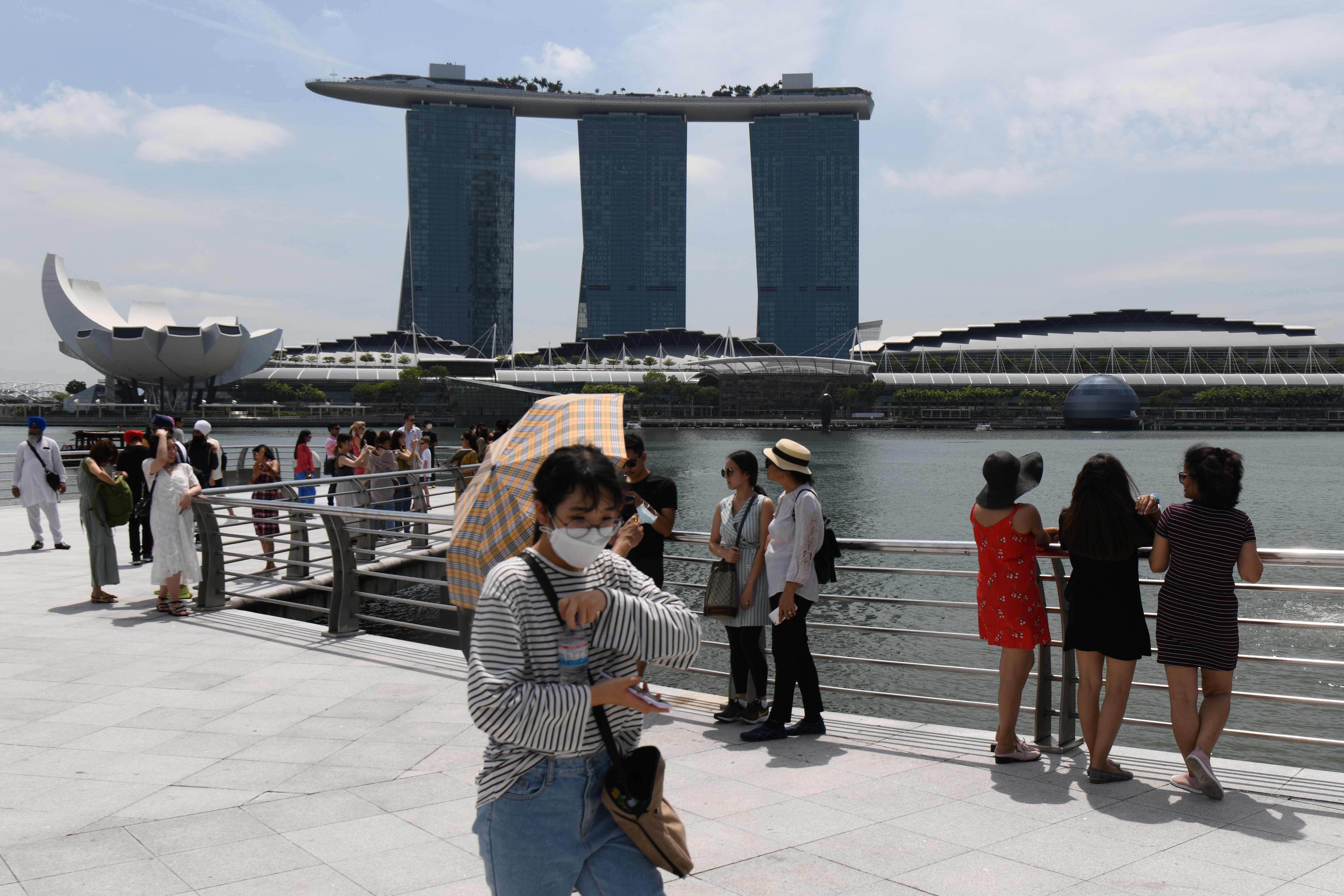 Pengunjung memakai masker pada 17 Februari 2020 saat di Merlion Park Singapura