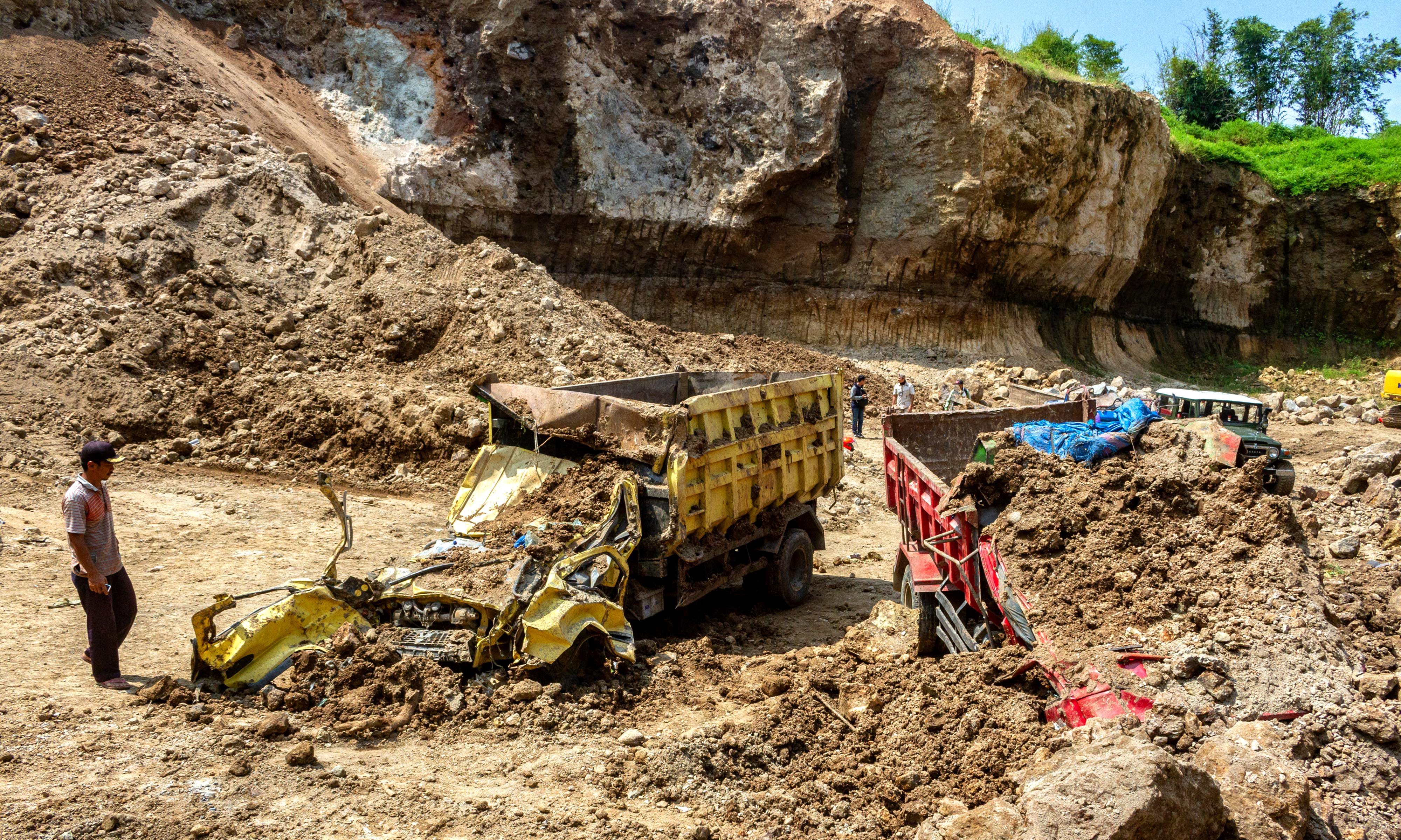 Warga mengamati truk yang ringsek akibat tertimbun longsor di area tambang galian C Desa Kebonbatur, Kabupaten Demak, Jawa Tengah.