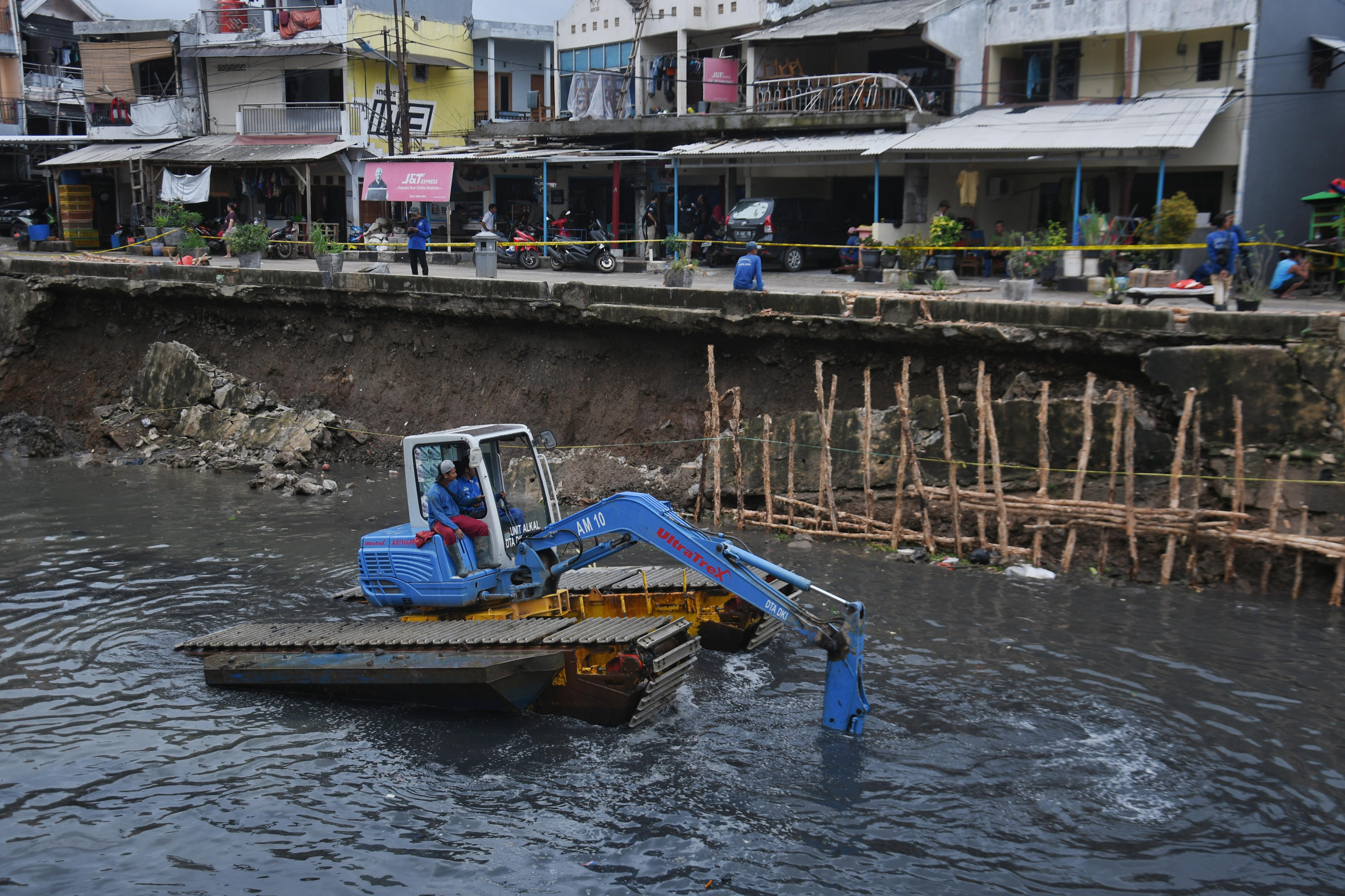 Petugas UPK Badan Air tengah memperbaiki turap Kali Sunter yang ambles di Jalan Cinta, Pulogadung, Jakarta Timur, Rabu (8/1)