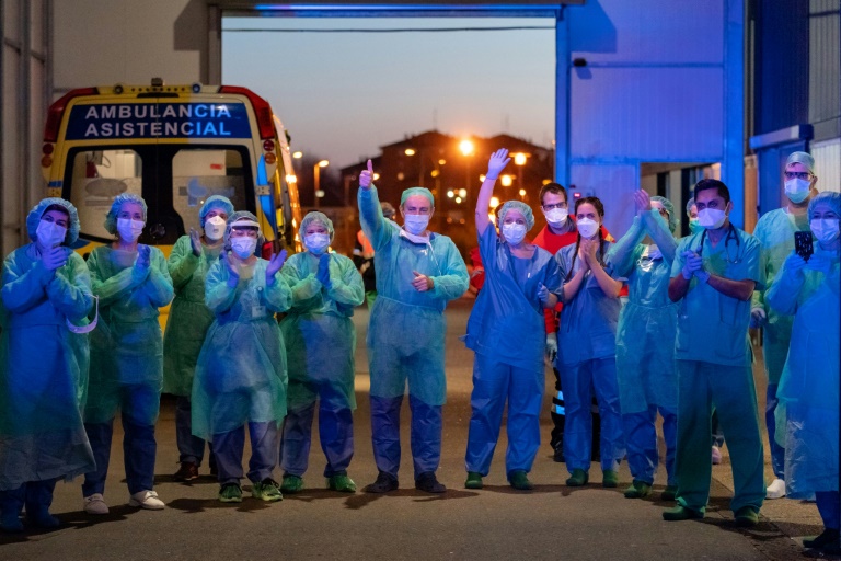 Petugas medis yang menangani pasien Covid-19 bertepuk disambut warga di luar sebuah rumah sakit di Burgos, Spanyol.