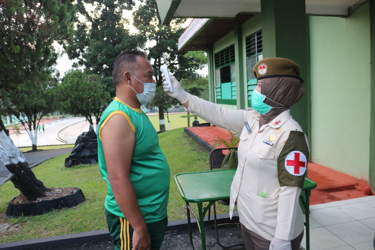 Petugas kesehatan sedang memeriksa suhu tubuh personel TNI Korem 022/Pantai Timur, Senin (23/3/2020)