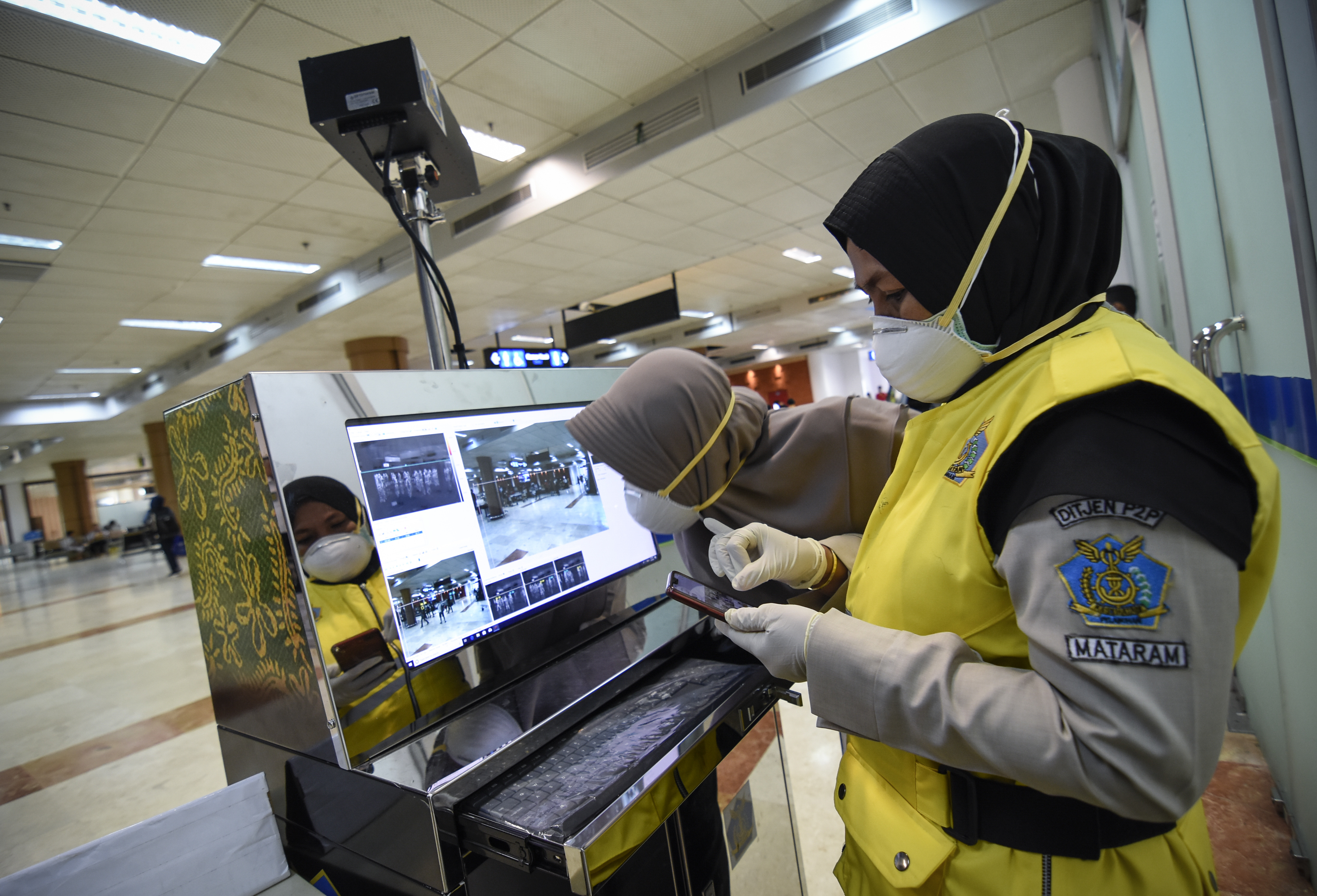 Petugas Kantor Kesehatan Pelabuhan (KKP) Lombok International Airport (LIA) mengoperasikan alat deteksi suhu tubuh atau thermoscan