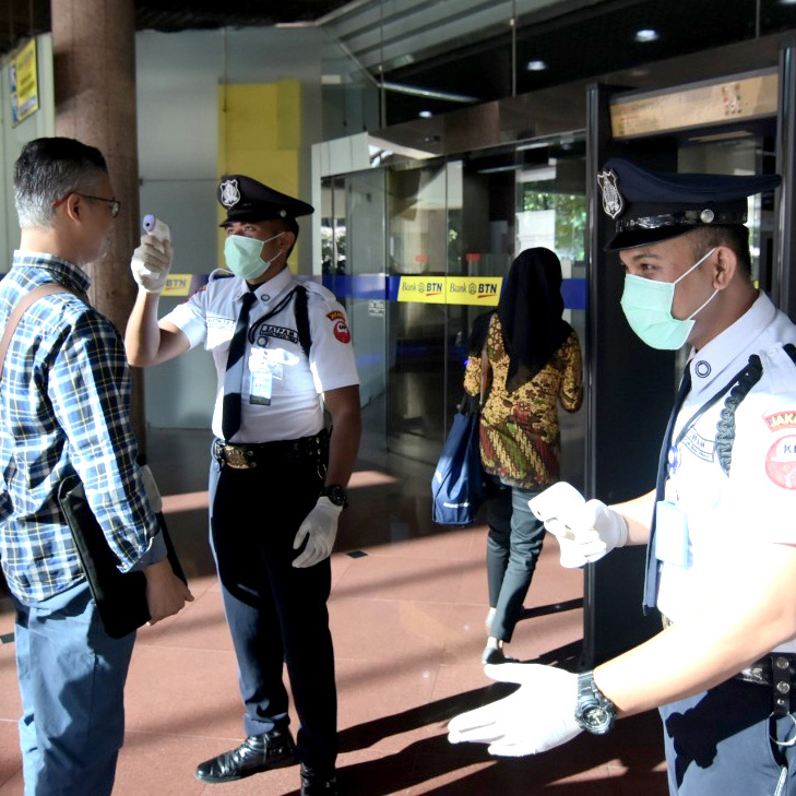 Petugas keamanan PT Bank Tabungan Negara (Persero) Tbk mengukur suhu karyawan dan pengunjung yang masuk ke lingkungan kerja perseroan.