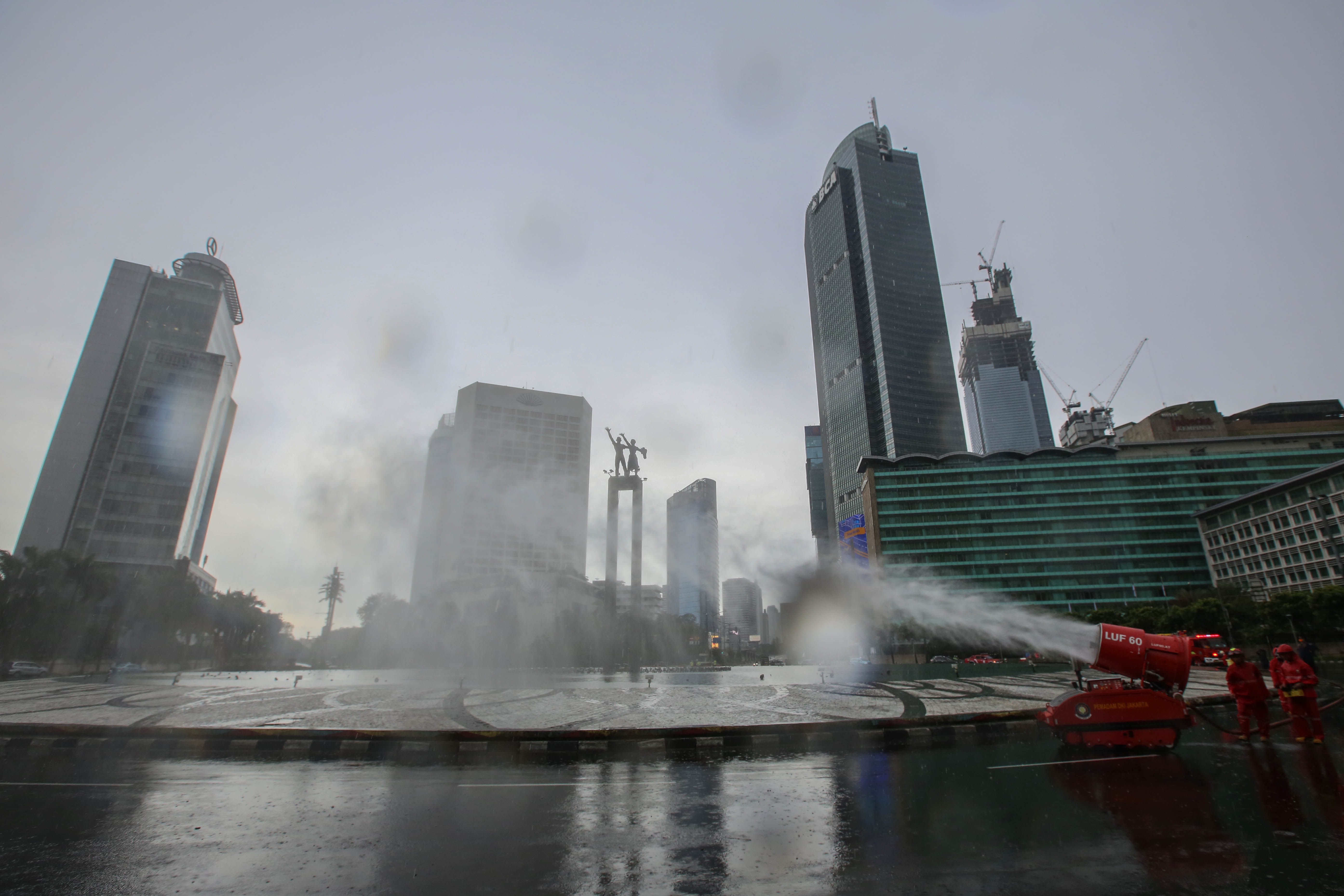 Petugas Damkar DKI sedang menyemprotkan disinfektan di Bundaran HI Jakarta