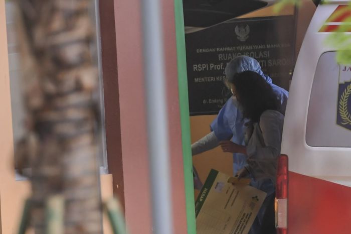 Petugas medis tengah mengantar wanita terduga covid-19.