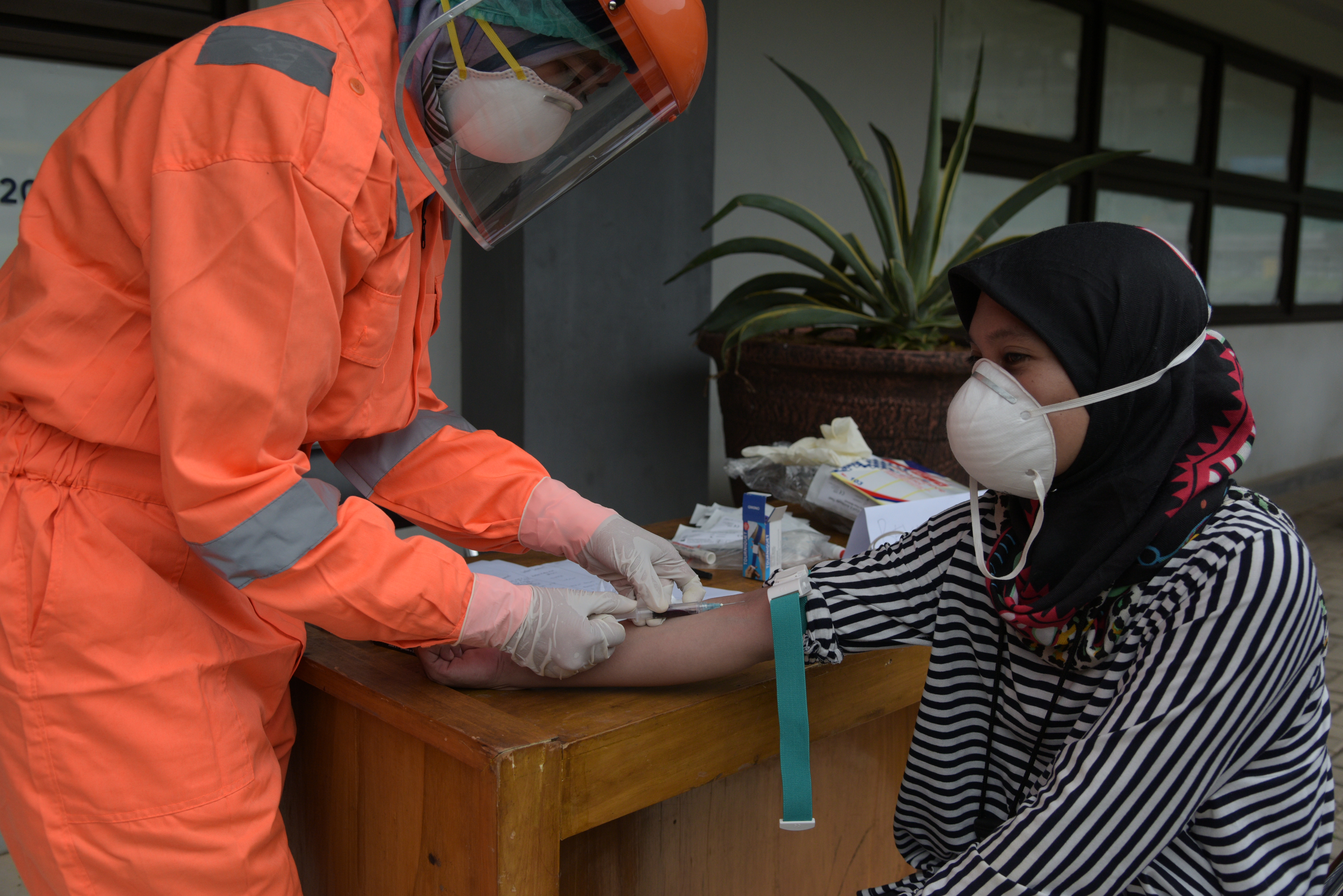 Petugas medis melaksanakan pengambilan sampel darah saat rapid test covid-19 di stadion Patriot Candrabhaga kota Bekasi