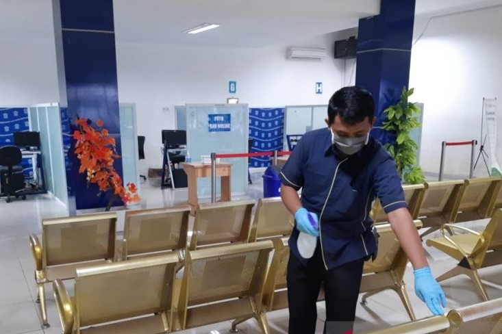 Petugas mensterilkan tempat kursi pada salah satu ruang tunggu permohonan surat izin mengemudi