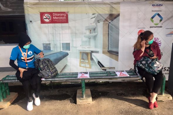 Calon penumpang duduk dengan jarak agak jauh dari penumpang lainnya  saat menunggu kereta  di Stasiun Sudimara, Tangerang Selatan, Banten.