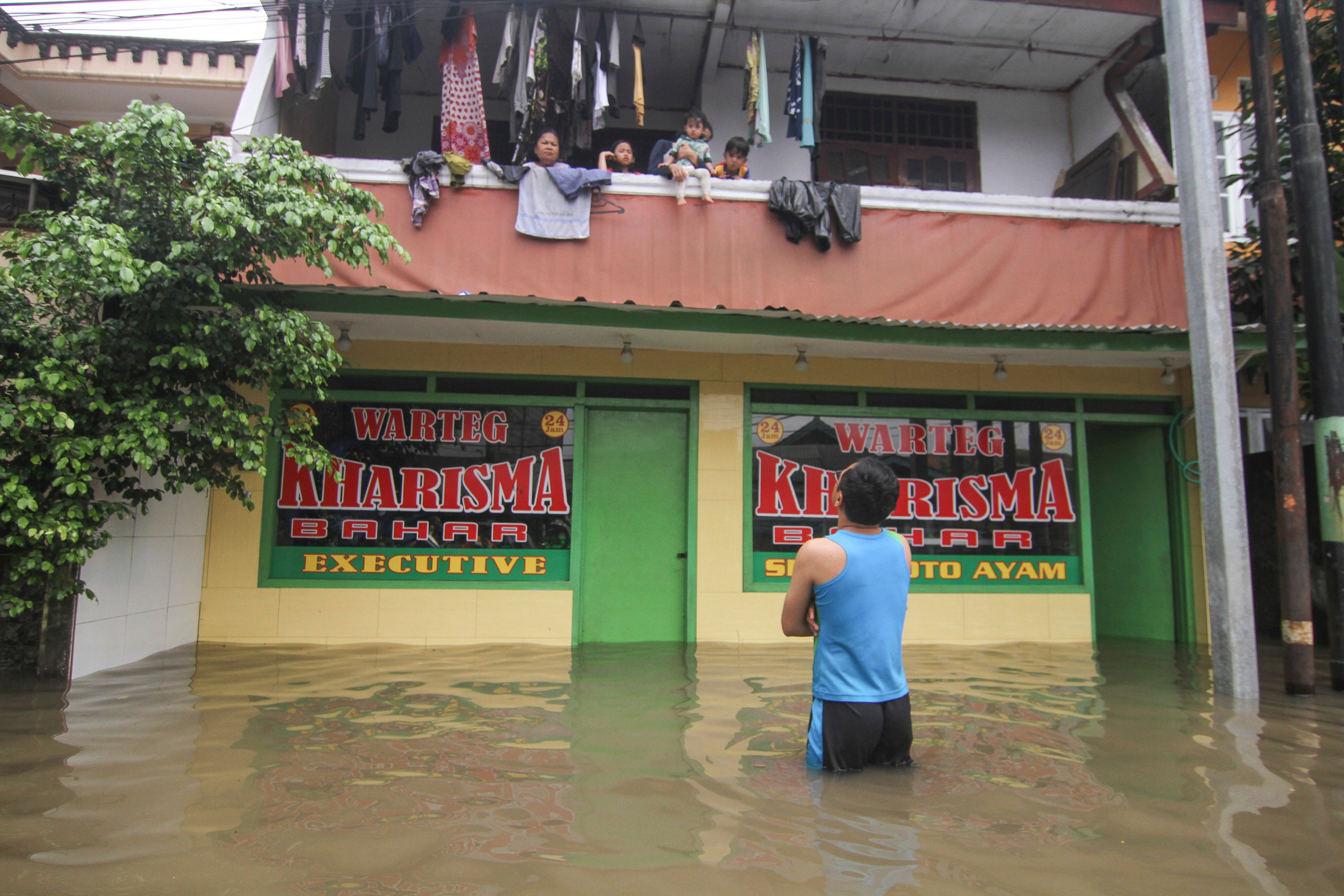 Sejumlah warga mengungsi di lantai dua rumahnya saat banjir di kawasan Kampung Makasar, Jakarta Timur, Selasa (25/2). 
