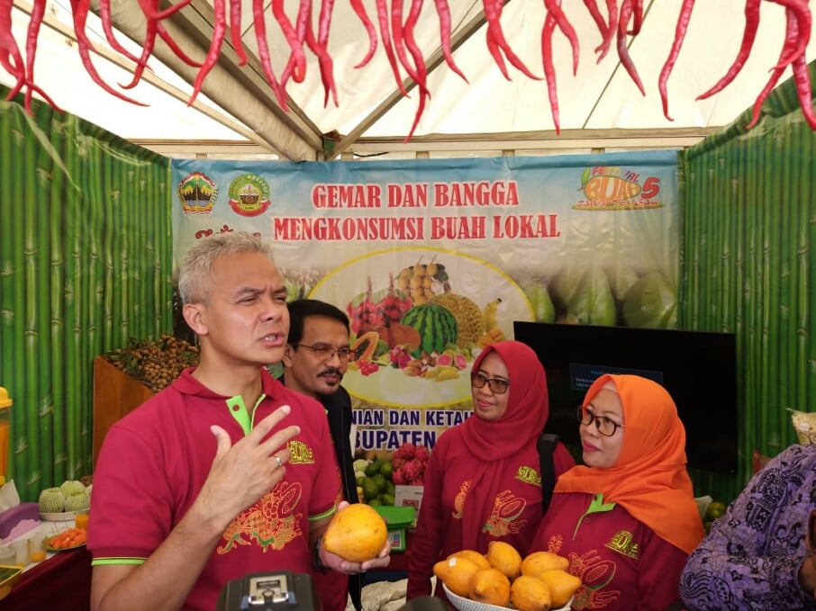 Gubernur Jawa Tengah Ganjar Pranowo saat mencicipi buah alkesa (sawo belanda) di acara pameran buah Jawa Tengah, Ungaran, Selasa (10/3/2020)