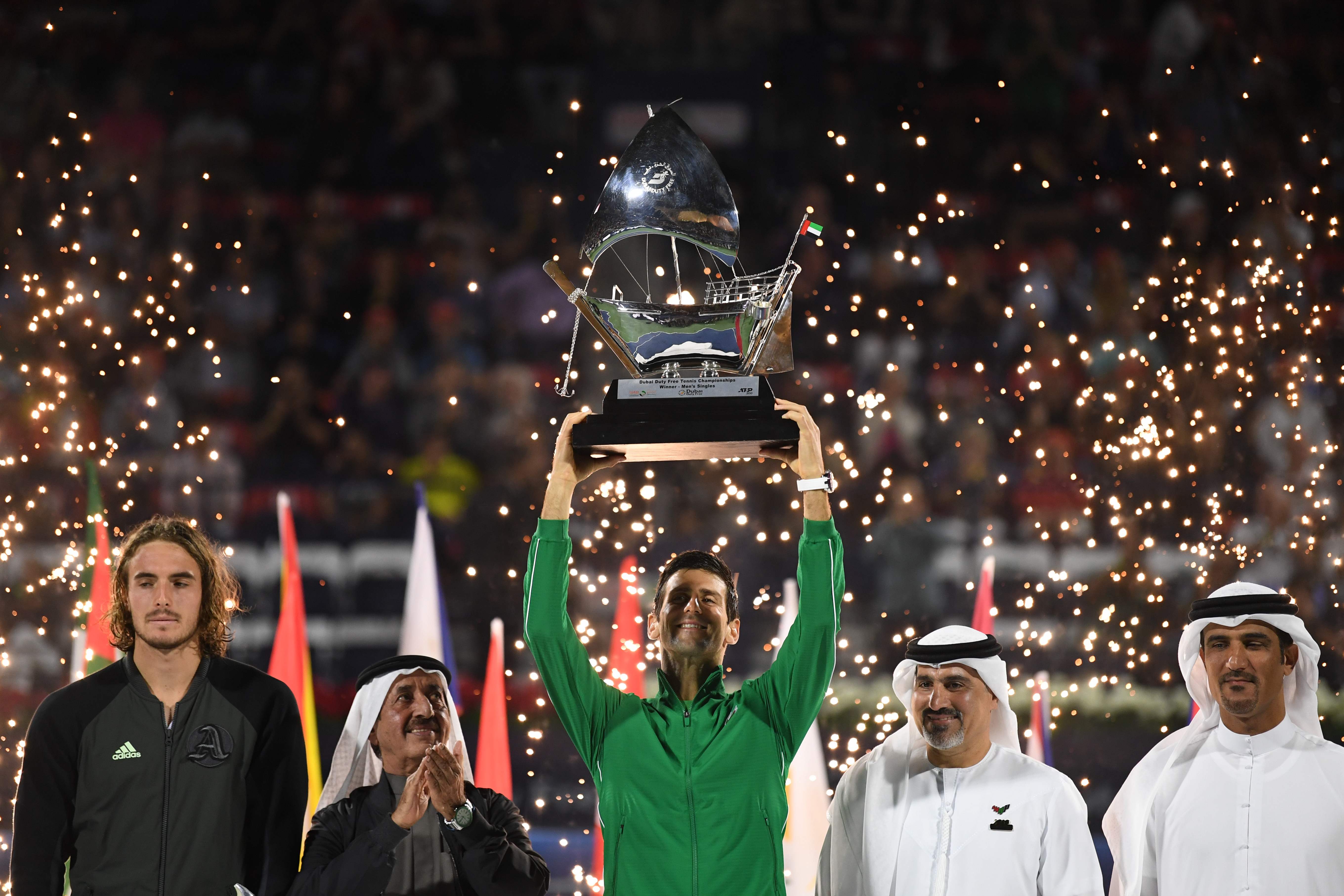 Novak Djokovic mengangkat trofi juara setelah menang di partai final ATP Dubai