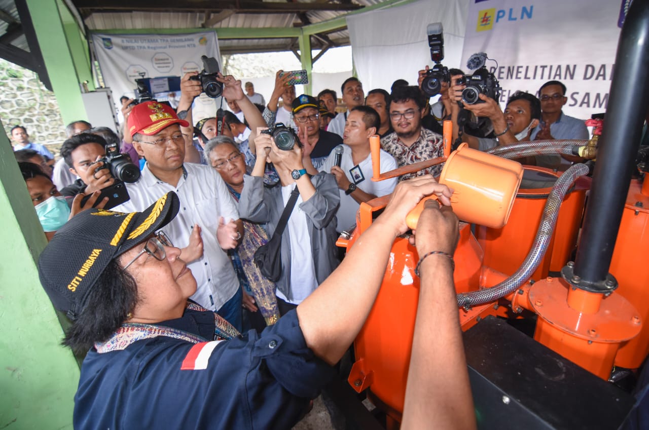 Menteri LHK Siti Nurbaya (kiri) memasukkan pellet ke dalam mesin pengubah pellet. 