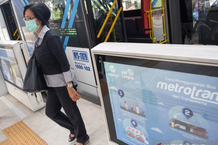 Penumpang memakai masker turun dari bus TransJakarta di Halte Budaran Hotel Indonesia