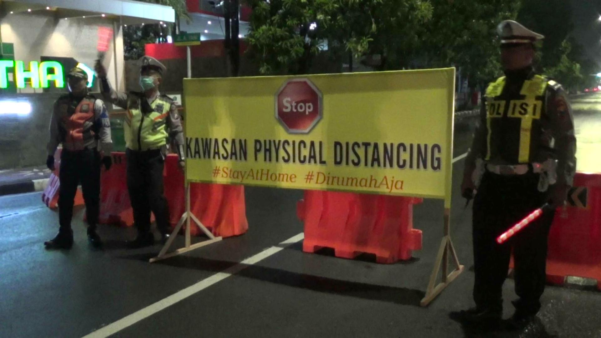 Polisi menutup ruas jalan di Sidoarjo untuk mencegah penyebaran virus korona.